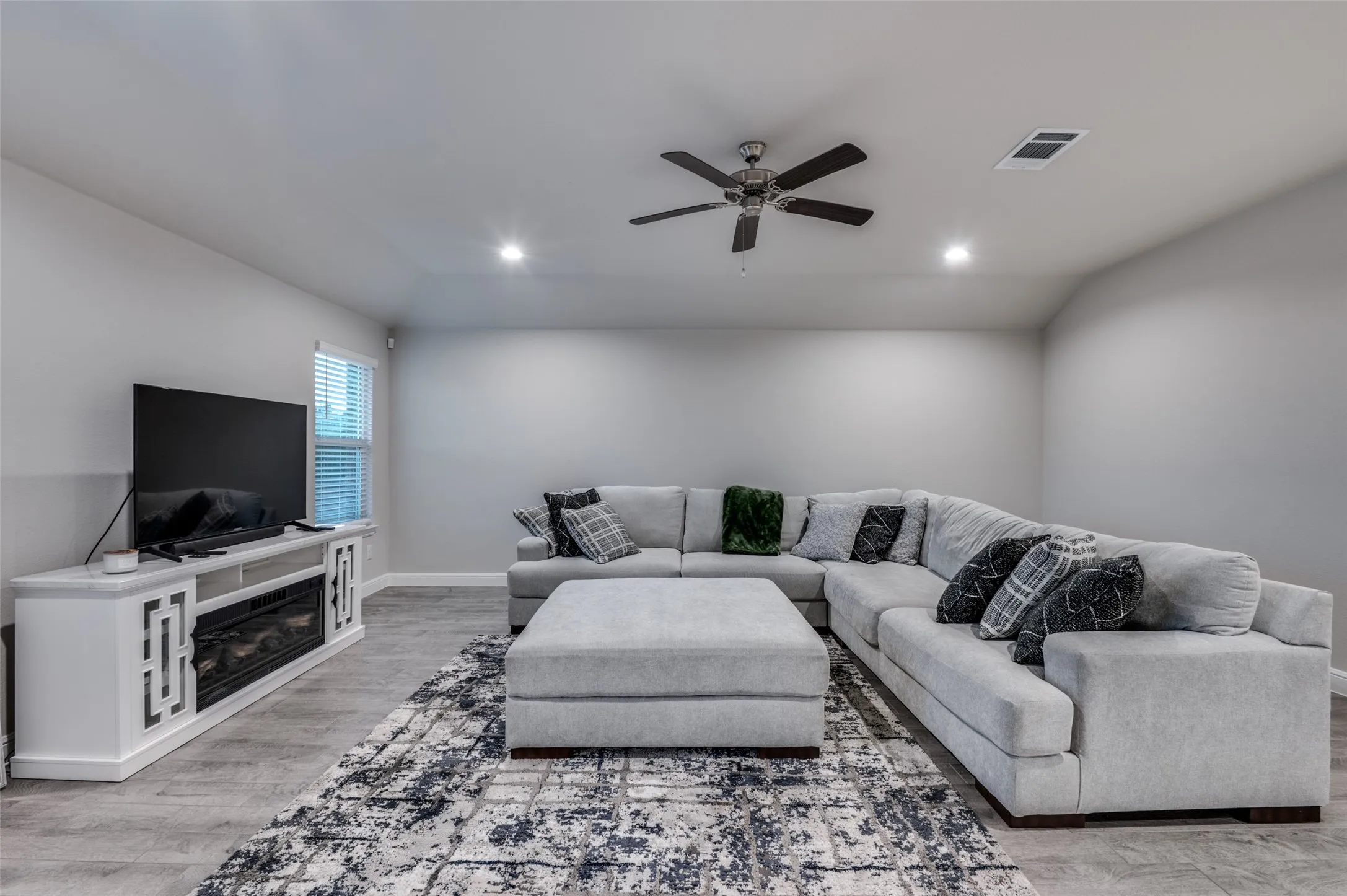 Living area featuring a ceiling fan, light wood-style flooring, and recessed lighting