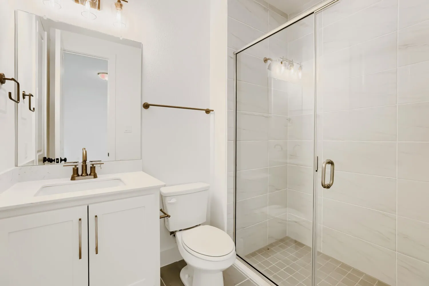 White vanity with integrated sink, bronze-finish faucet, and coordinating hardware