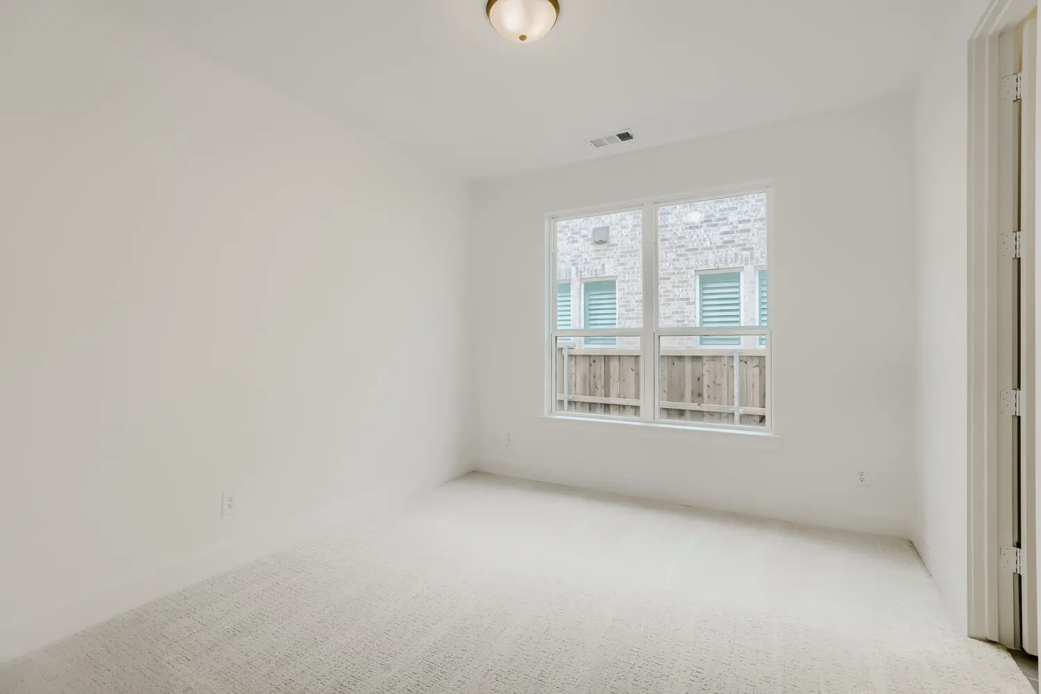 Wall-to-wall carpeting, white walls, and a multi-pane window