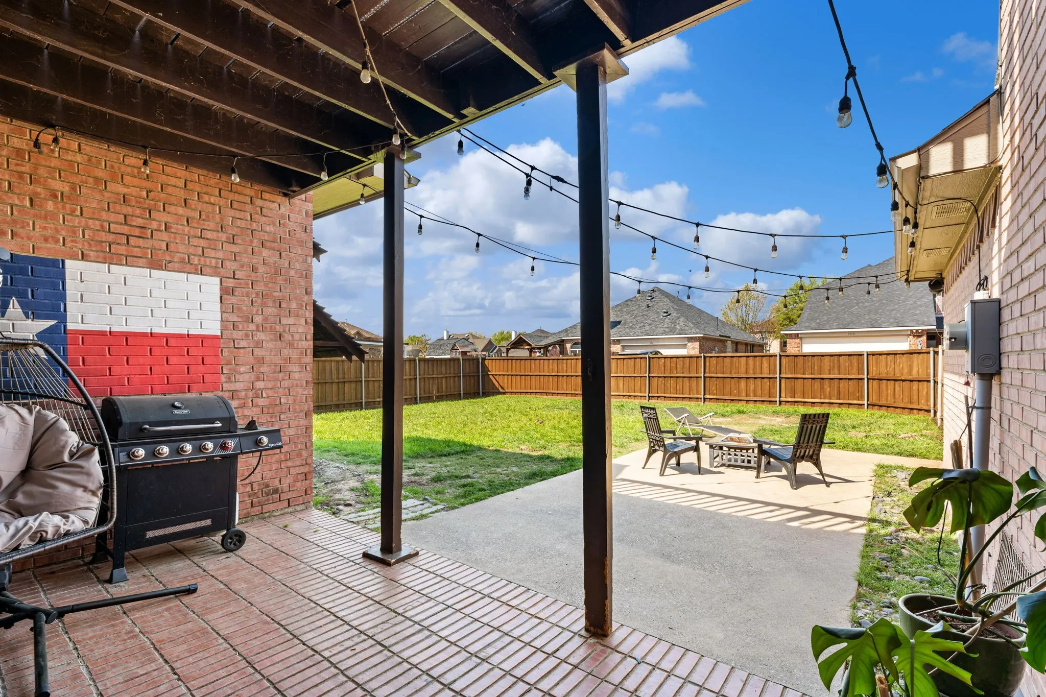 Fenced backyard featuring a patio, a fire pit, and a grill