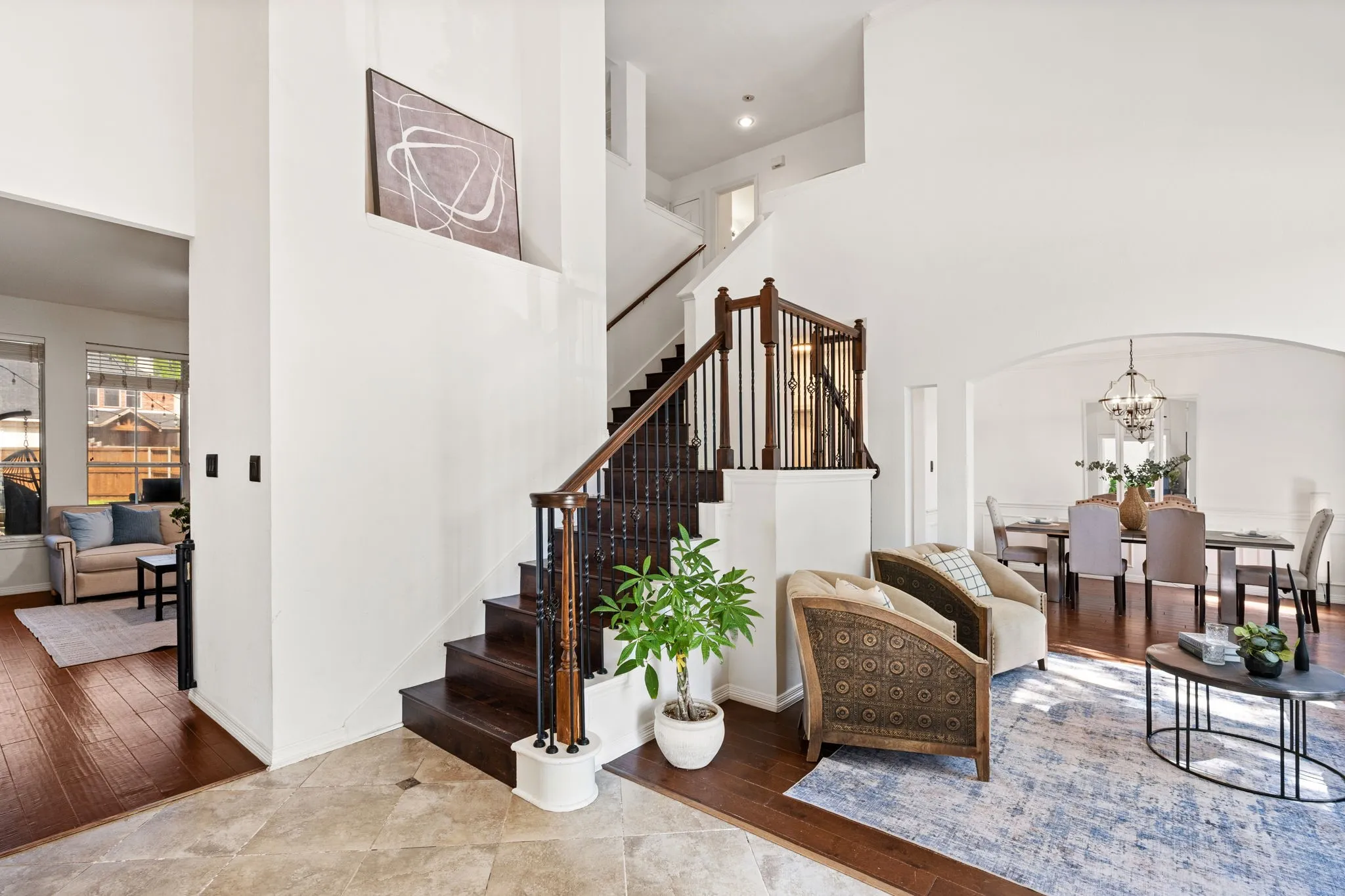 Stairway featuring hardwood / wood-style floors, suspended lighting, a high ceiling, and arched walkways