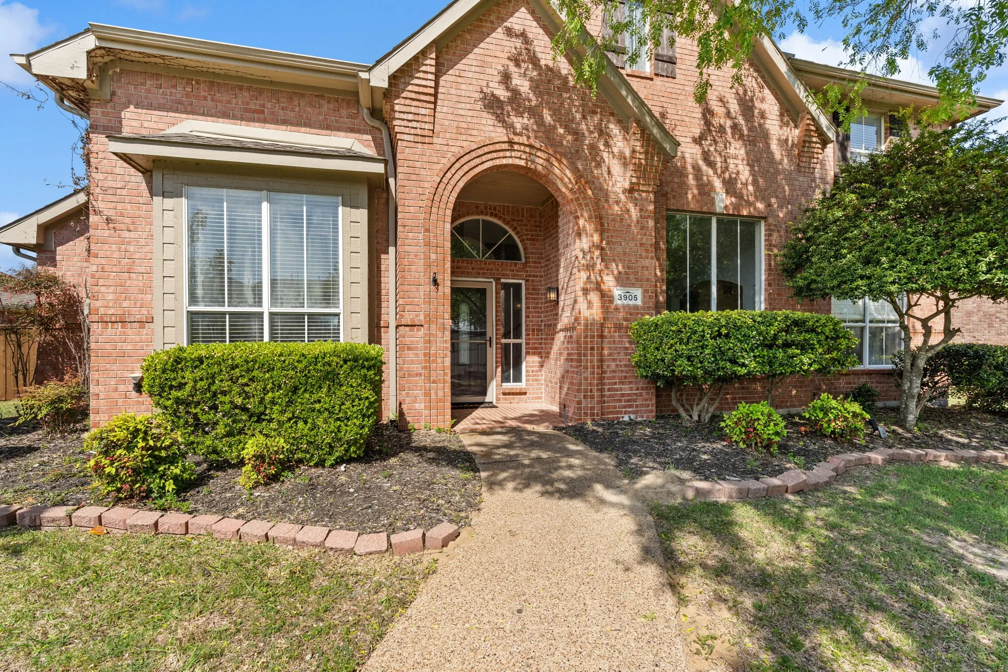 View of front facade with brick siding and a front yard