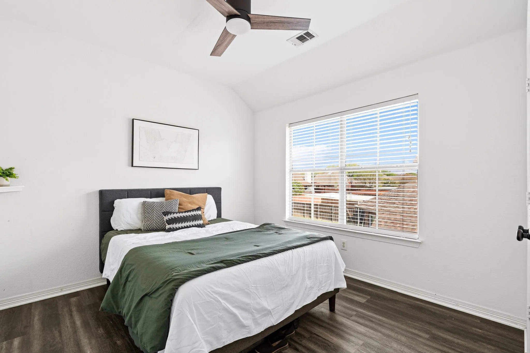 Bedroom with lofted ceiling, dark wood-style floors, and a ceiling fan