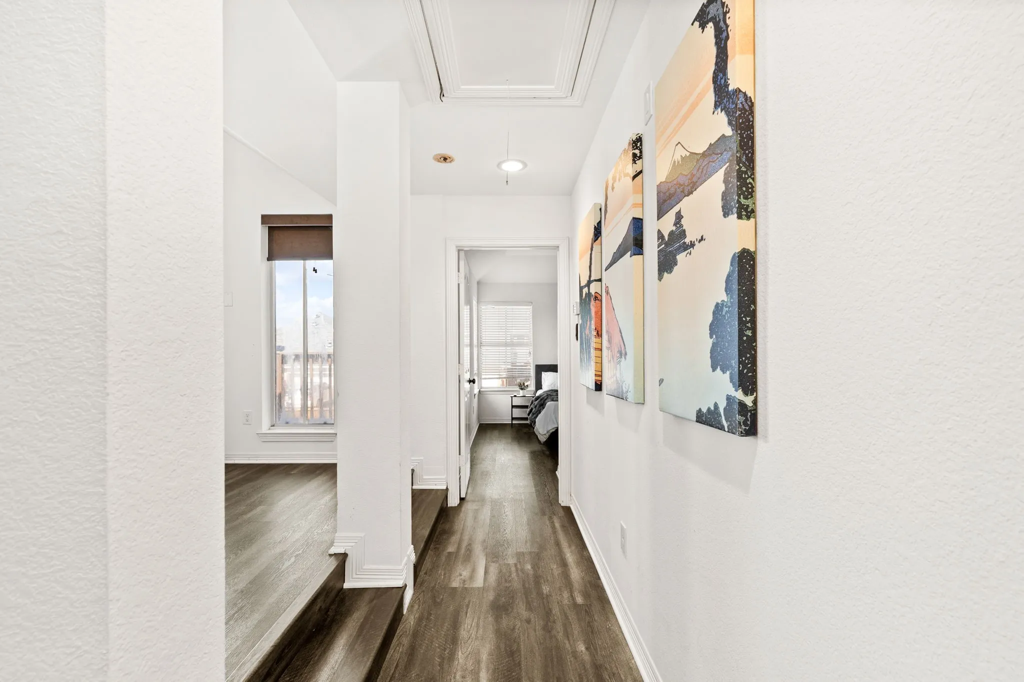 Hallway with dark wood-type flooring and a textured wall to Gameroom