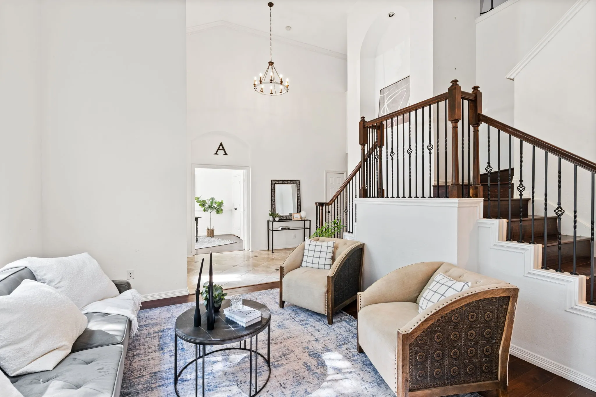 Living room featuring wood finished floors, a high ceiling, and hanging lights