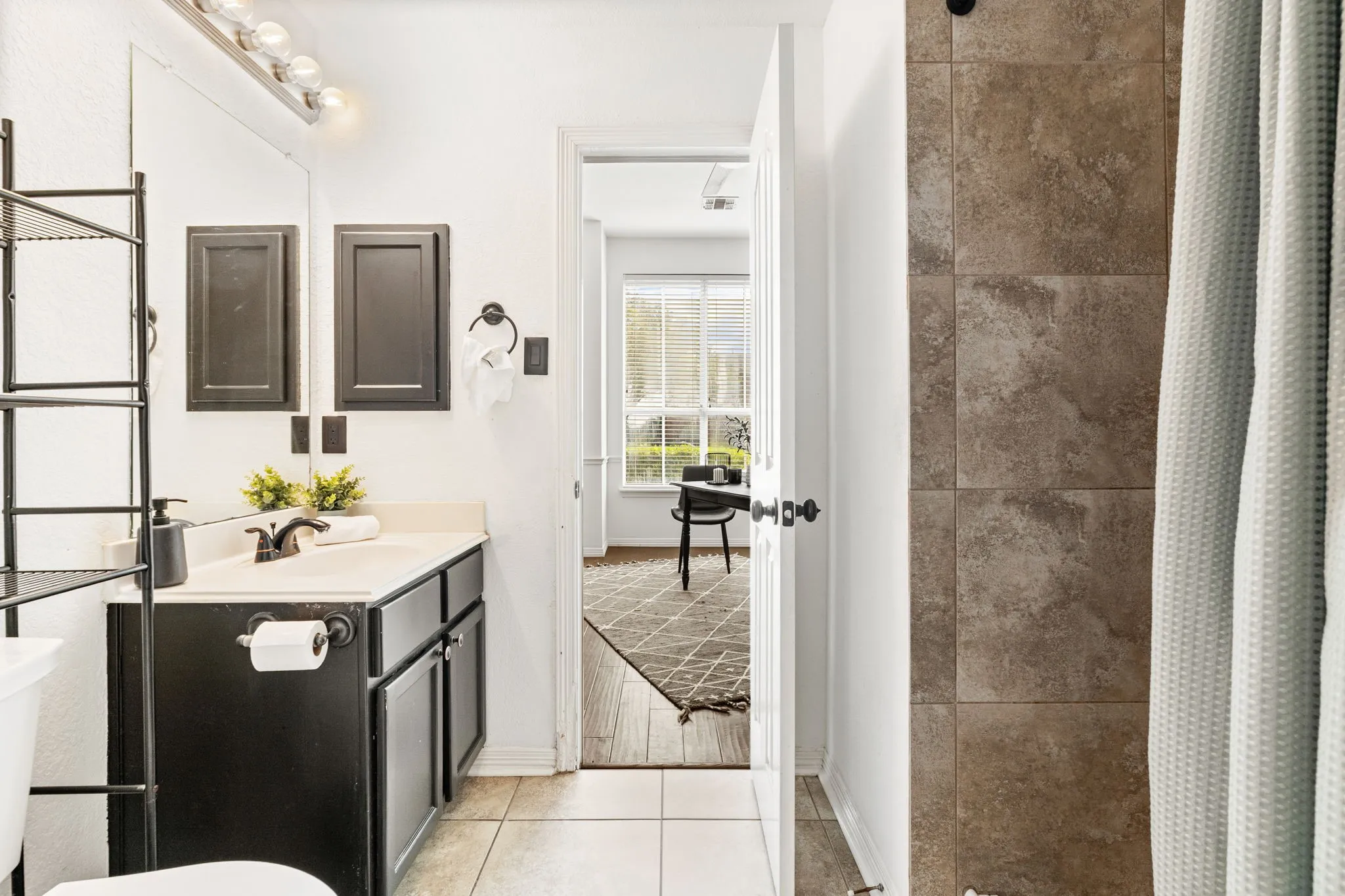 Full bathroom with a stall shower, vanity, and light tile patterned floors