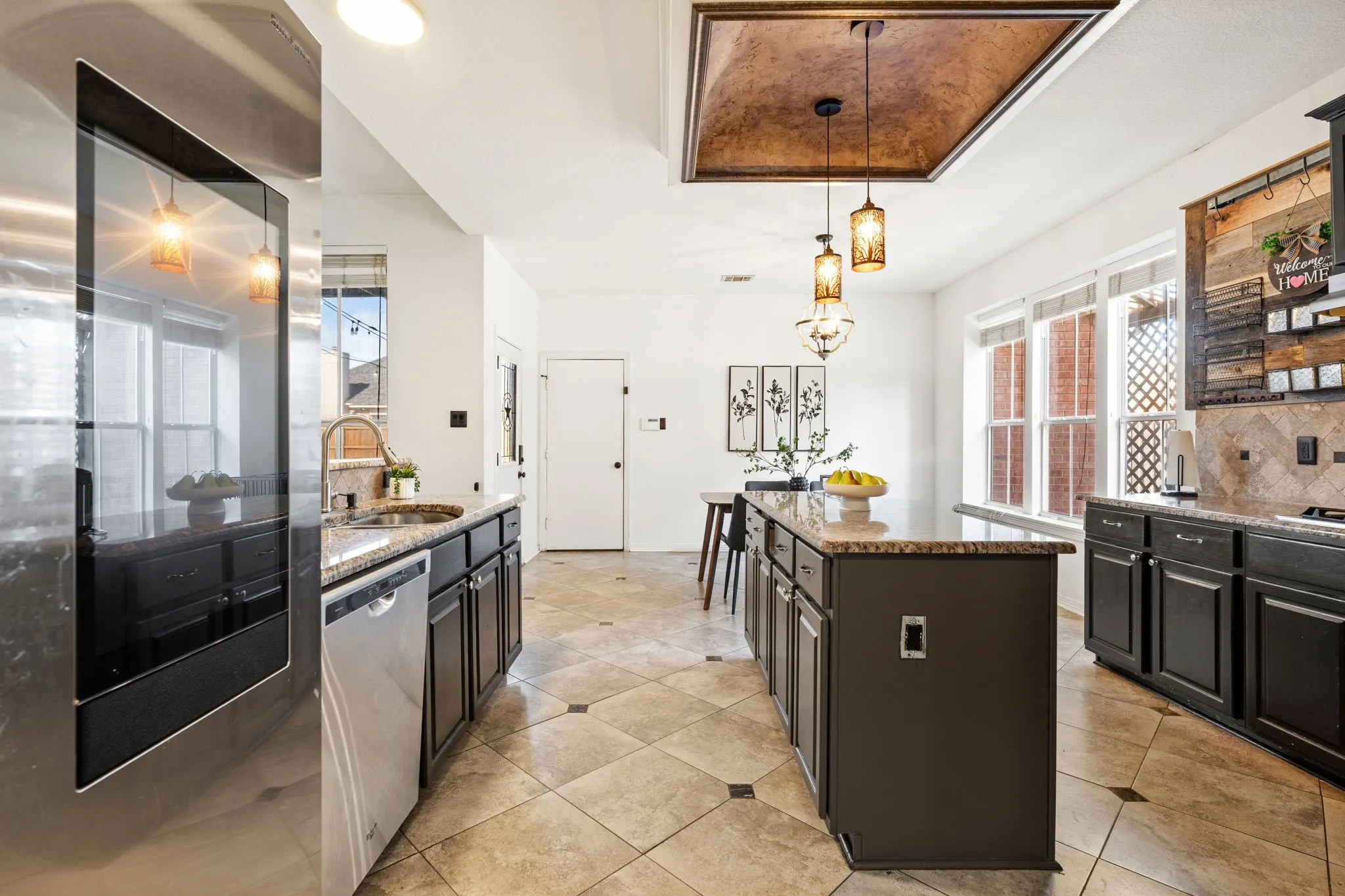 Kitchen with stainless steel appliances, tasteful backsplash, light stone countertops, and a kitchen island