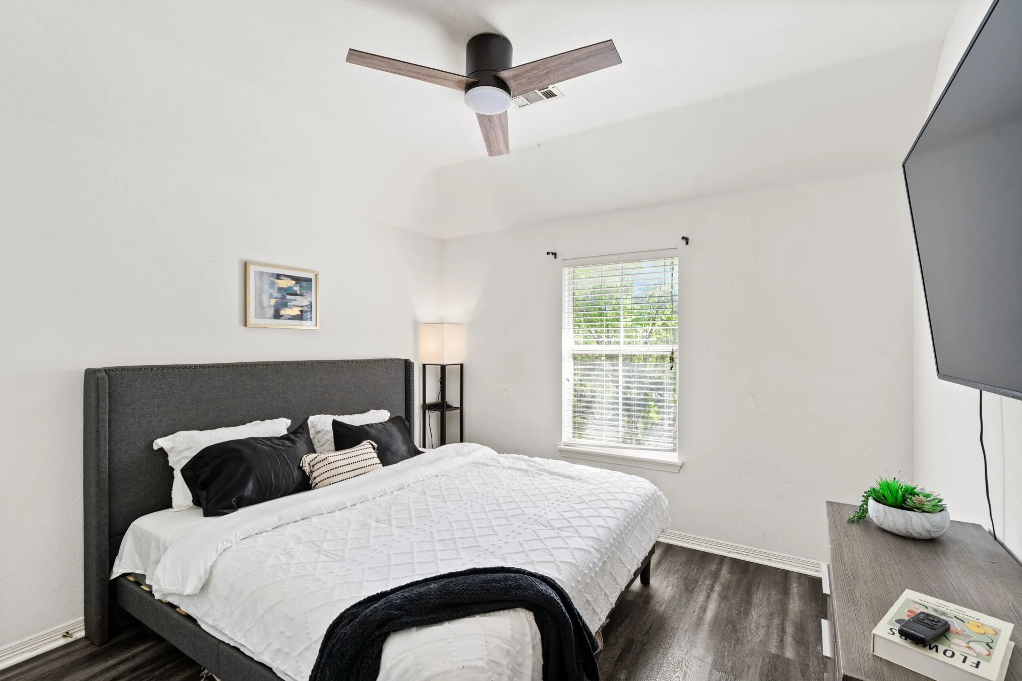 Bedroom with dark wood-type flooring and a ceiling fan