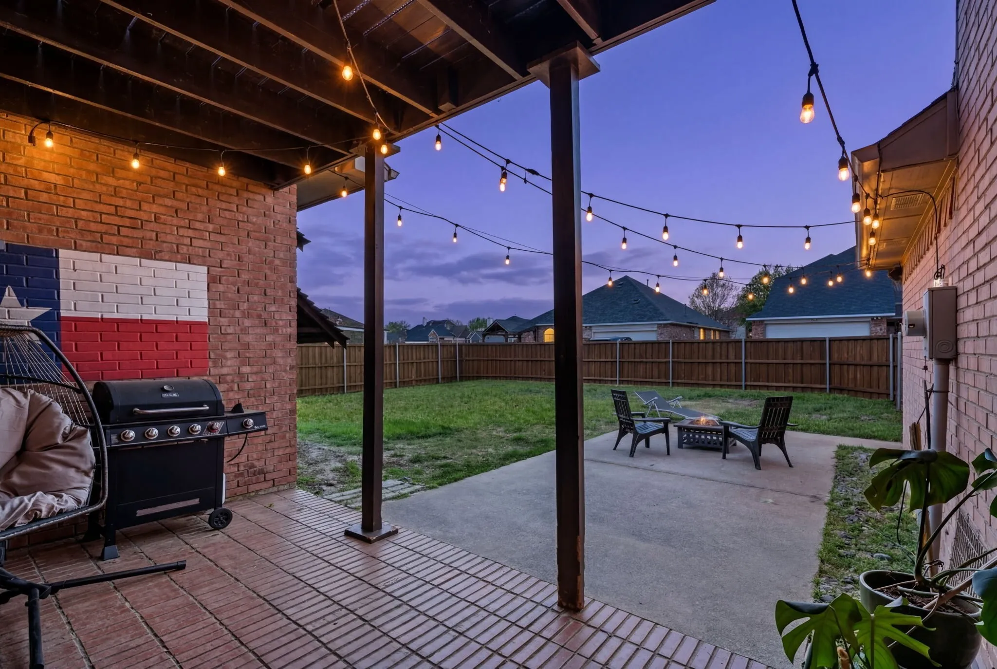Fenced backyard featuring a patio, a fire pit, and a grill