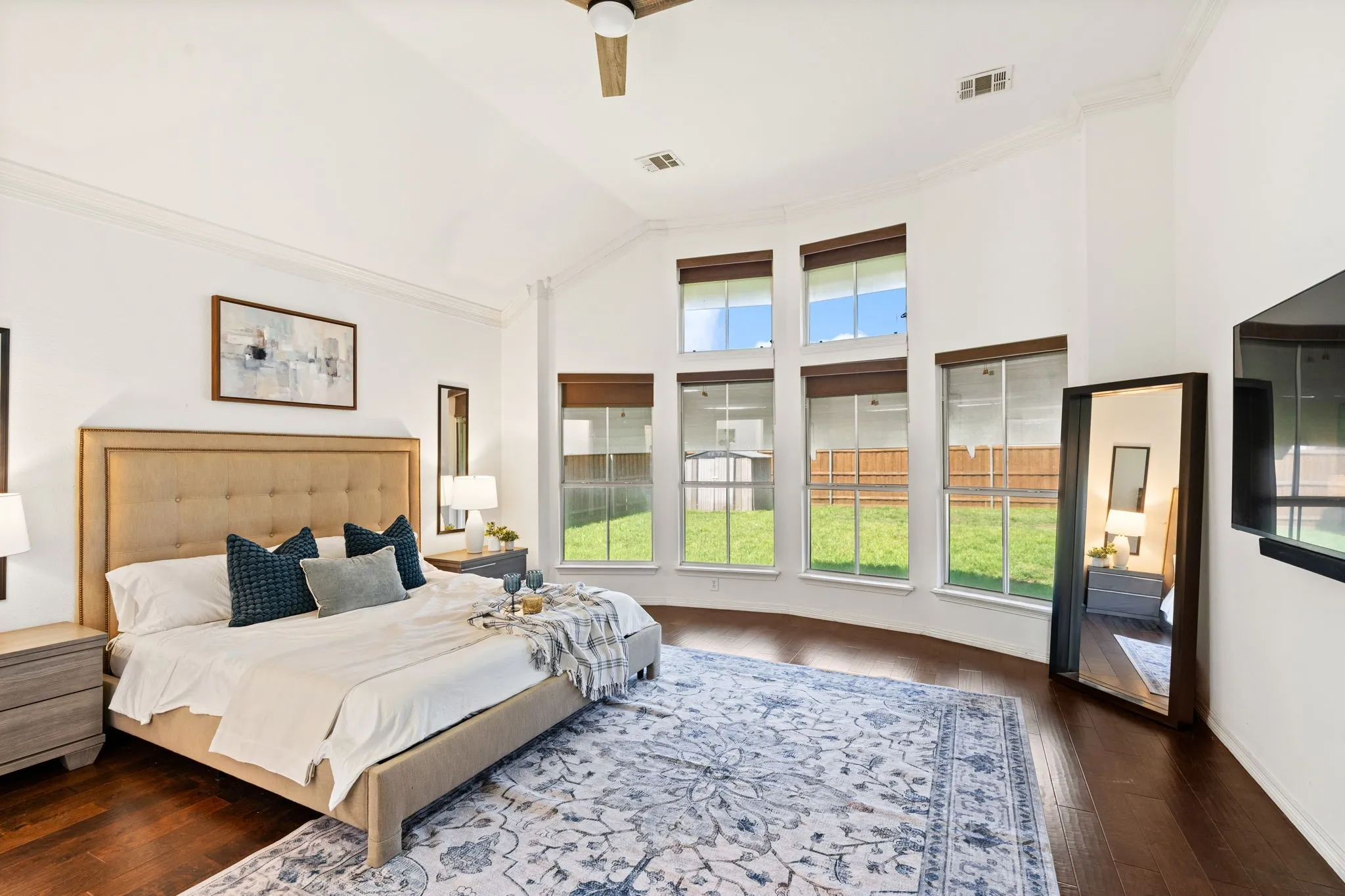 Bedroom with crown molding, dark wood-style floors, a ceiling fan, and lofted ceiling