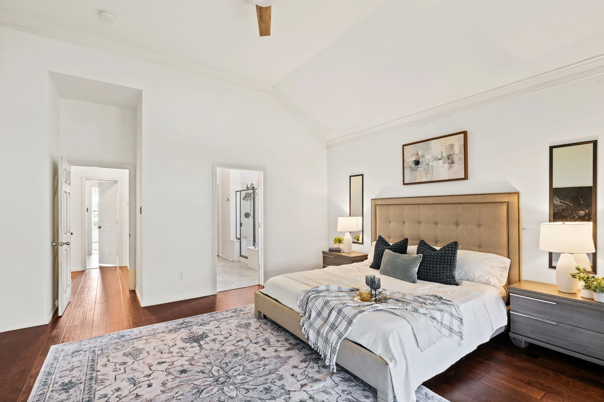 Bedroom with ornamental molding, dark wood-type flooring, lofted ceiling, a ceiling fan, and ensuite bathroom