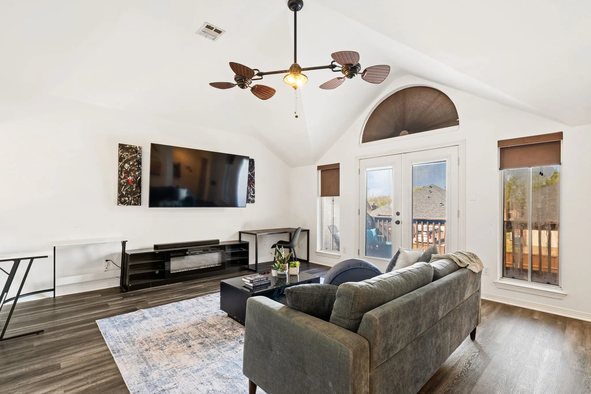 Living area featuring a ceiling fan, french doors, dark wood-type flooring, and a high ceiling