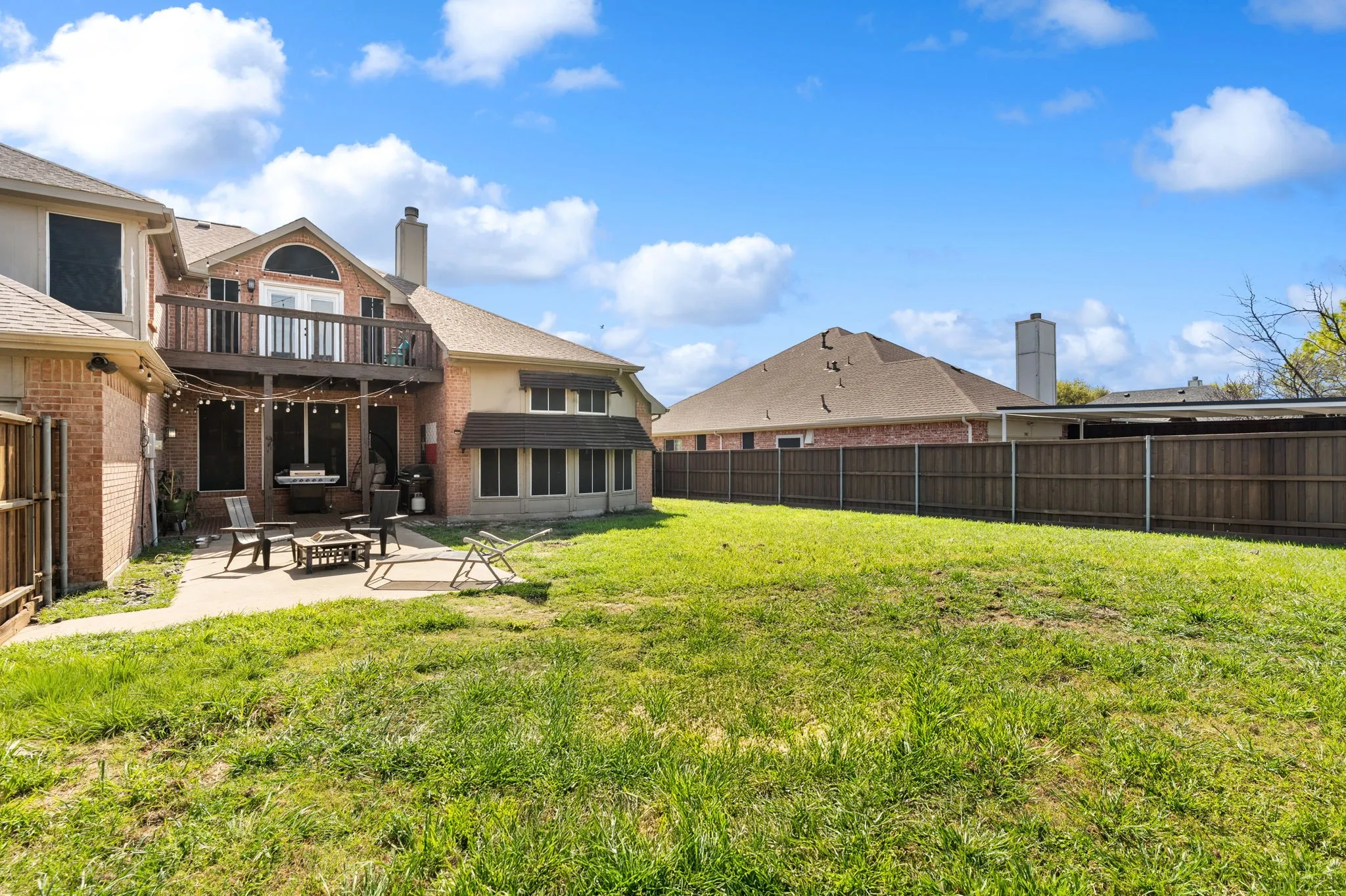 Fenced backyard with a patio area and a fire pit