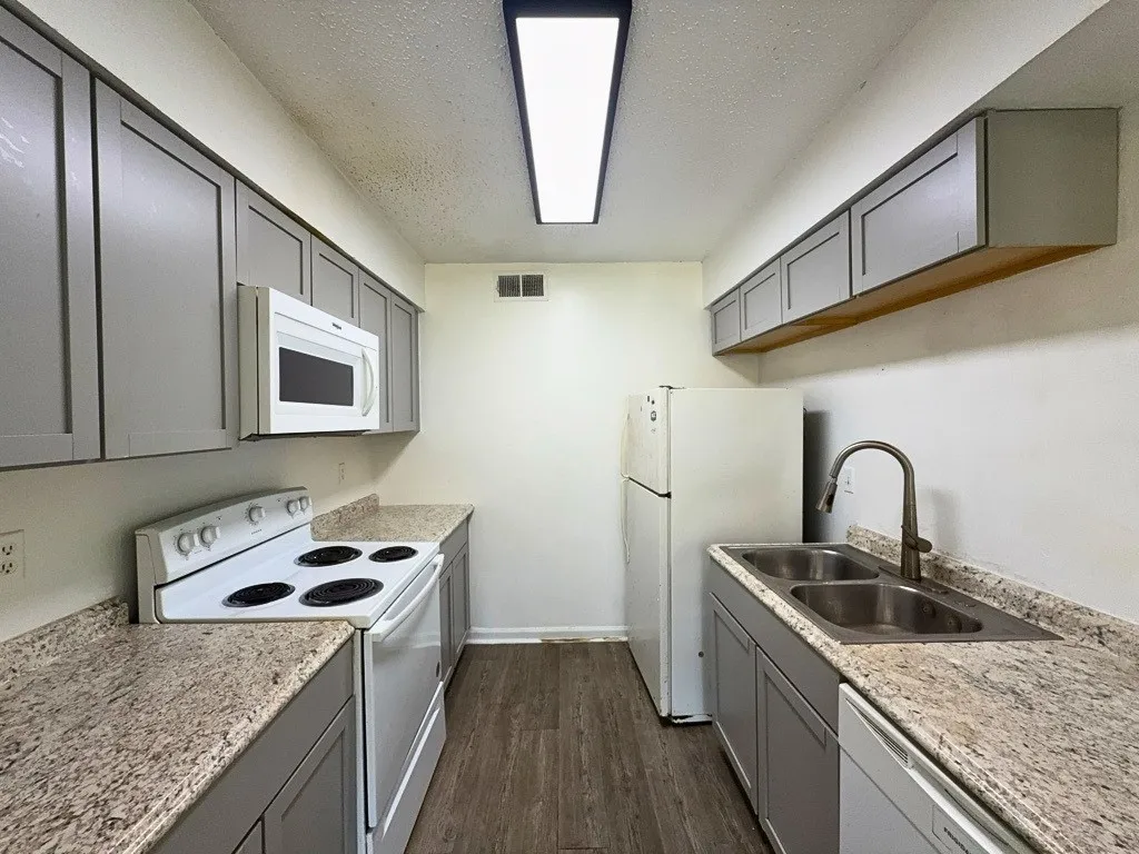 Kitchen with electric range, microwave, and refrigerator