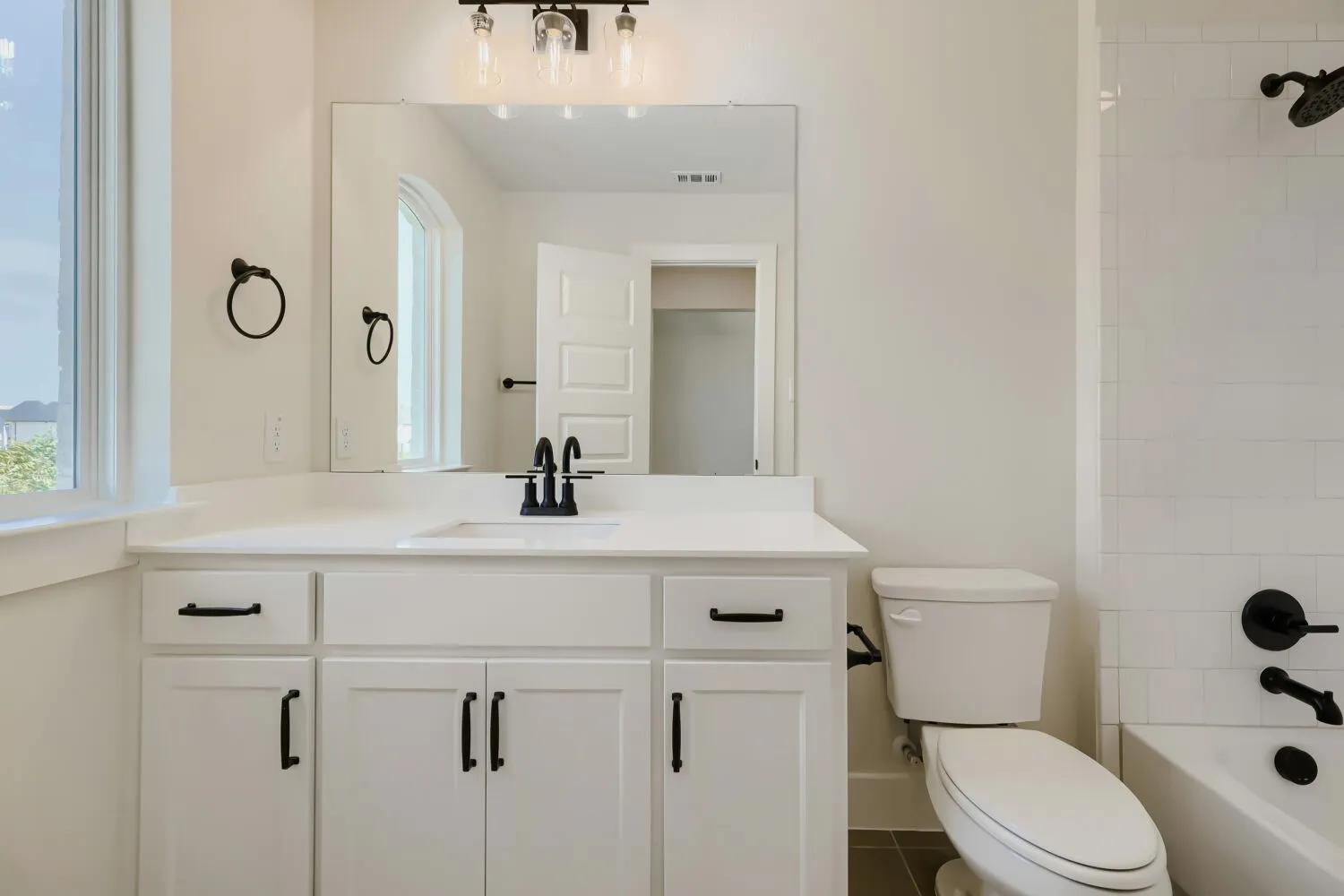 White vanity with integrated sink and matte black fixtures