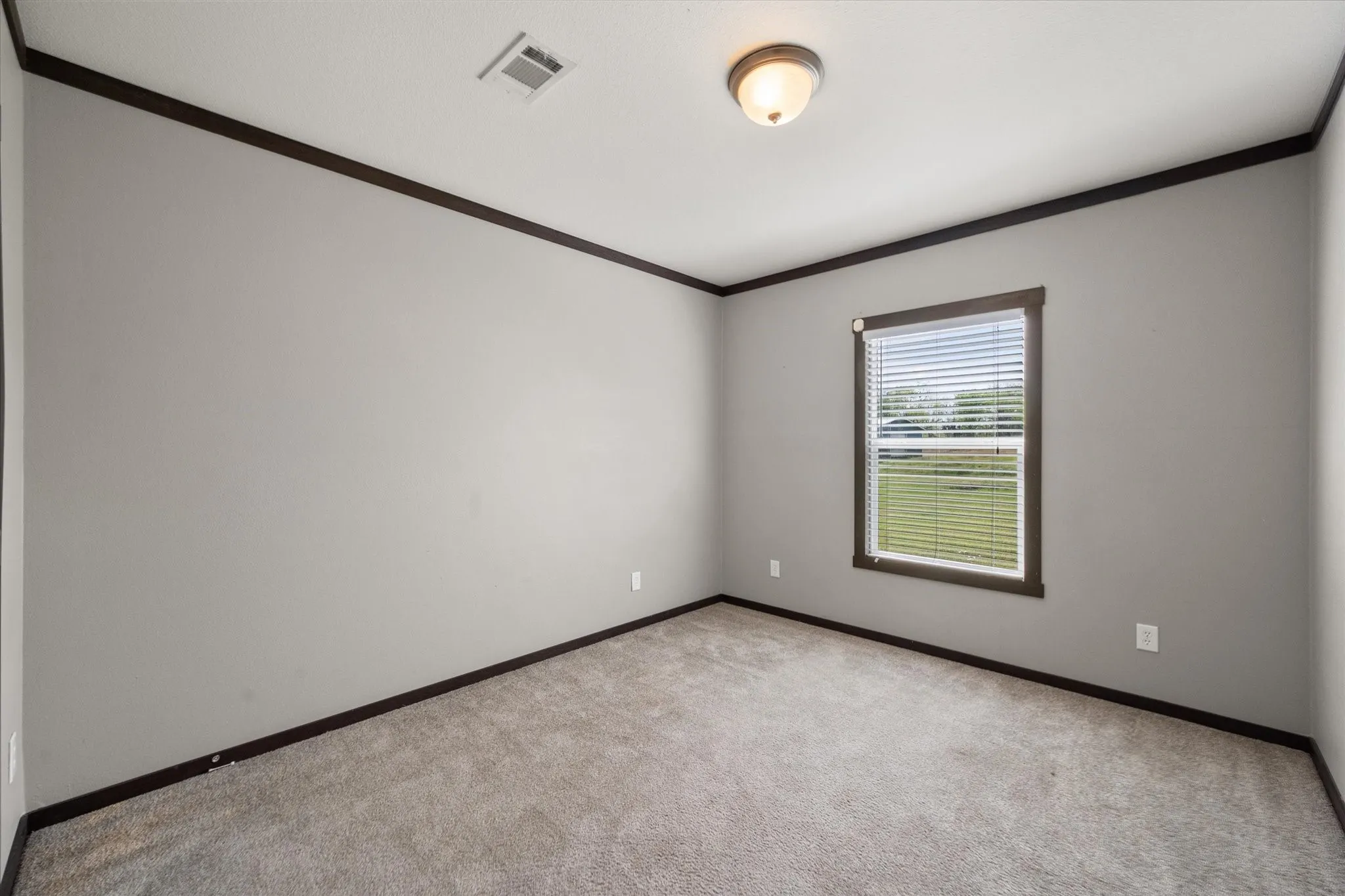 Bright secondary bedroom with neutral finishes and flexible space for guests, family, or a home office setup.