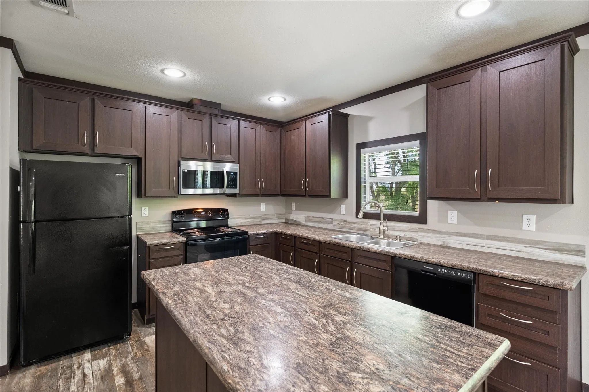 Oversized kitchen island offers additional seating, storage, and gathering space for family and guests.