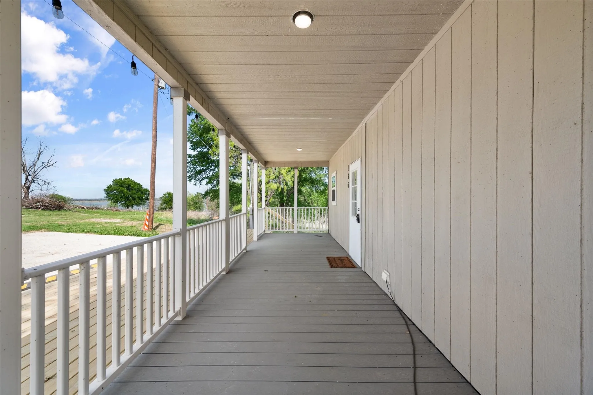 Full-length covered porch offers a welcoming entrance and relaxing outdoor living space for lake area living.