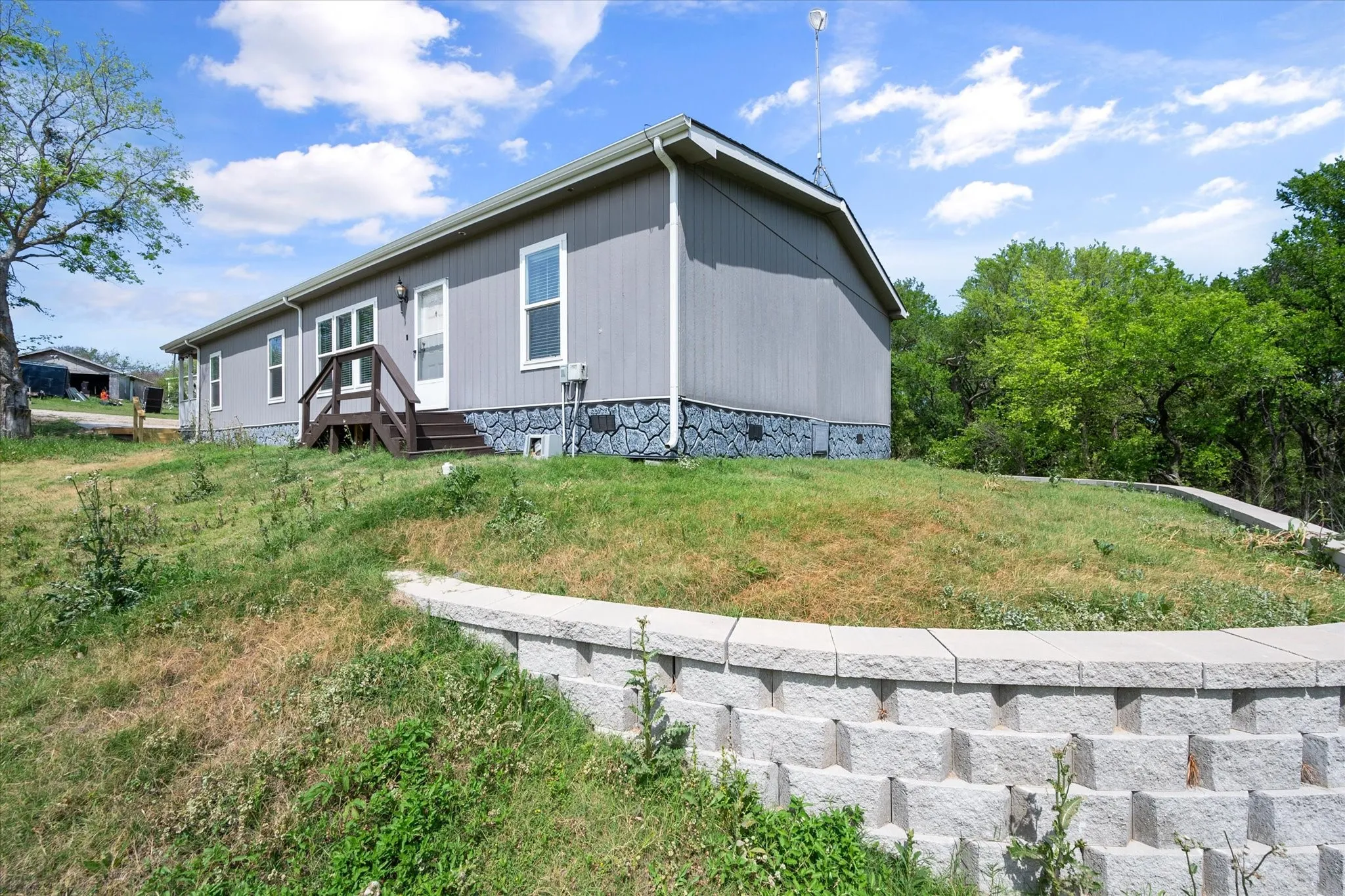 Well-maintained exterior with updated decking and elevated positioning creates inviting curb appeal for lake-area living.
