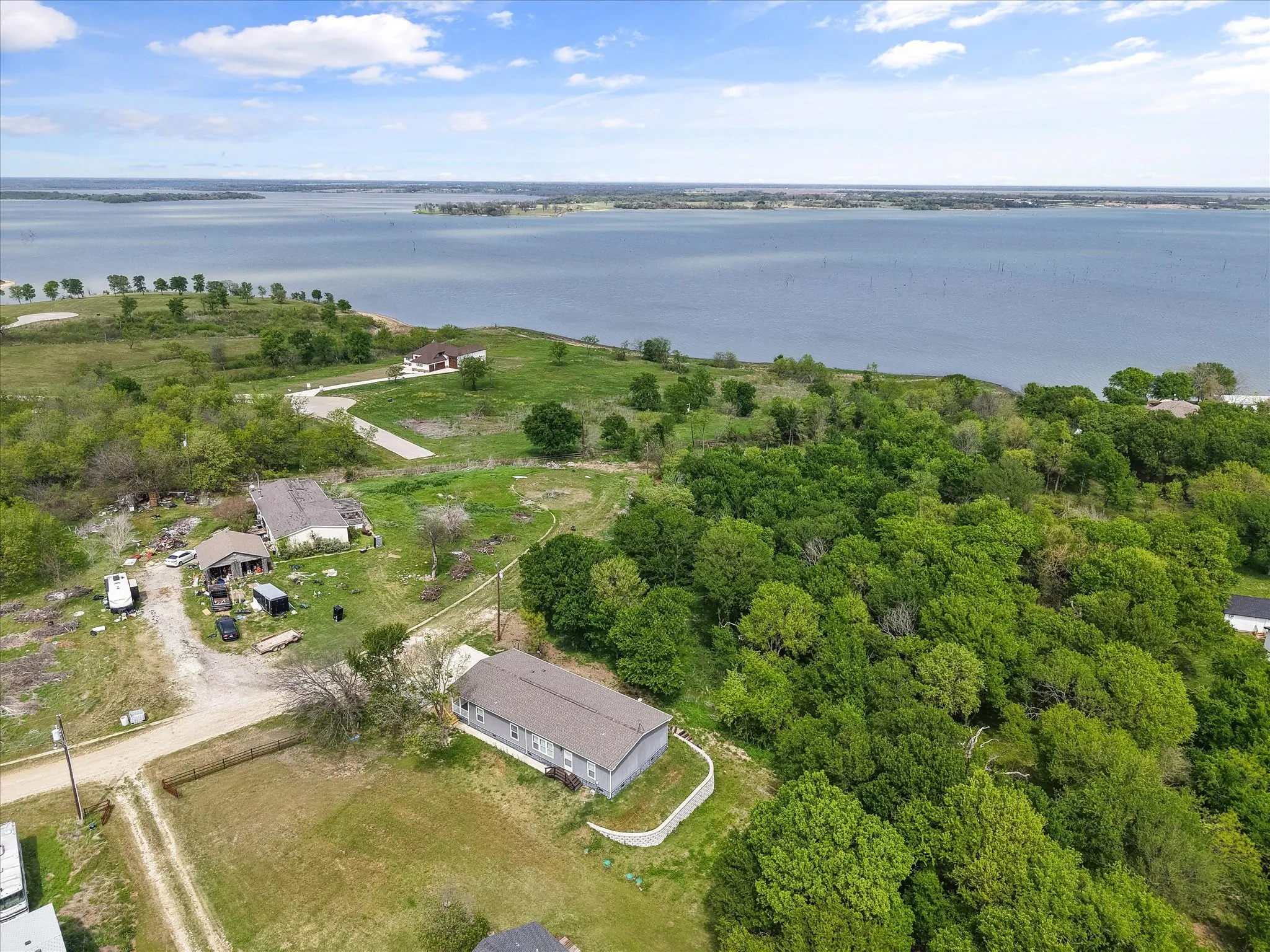 Aerial view showcasing the home’s peaceful setting near Richland Chambers Lake with mature trees and open surroundings.