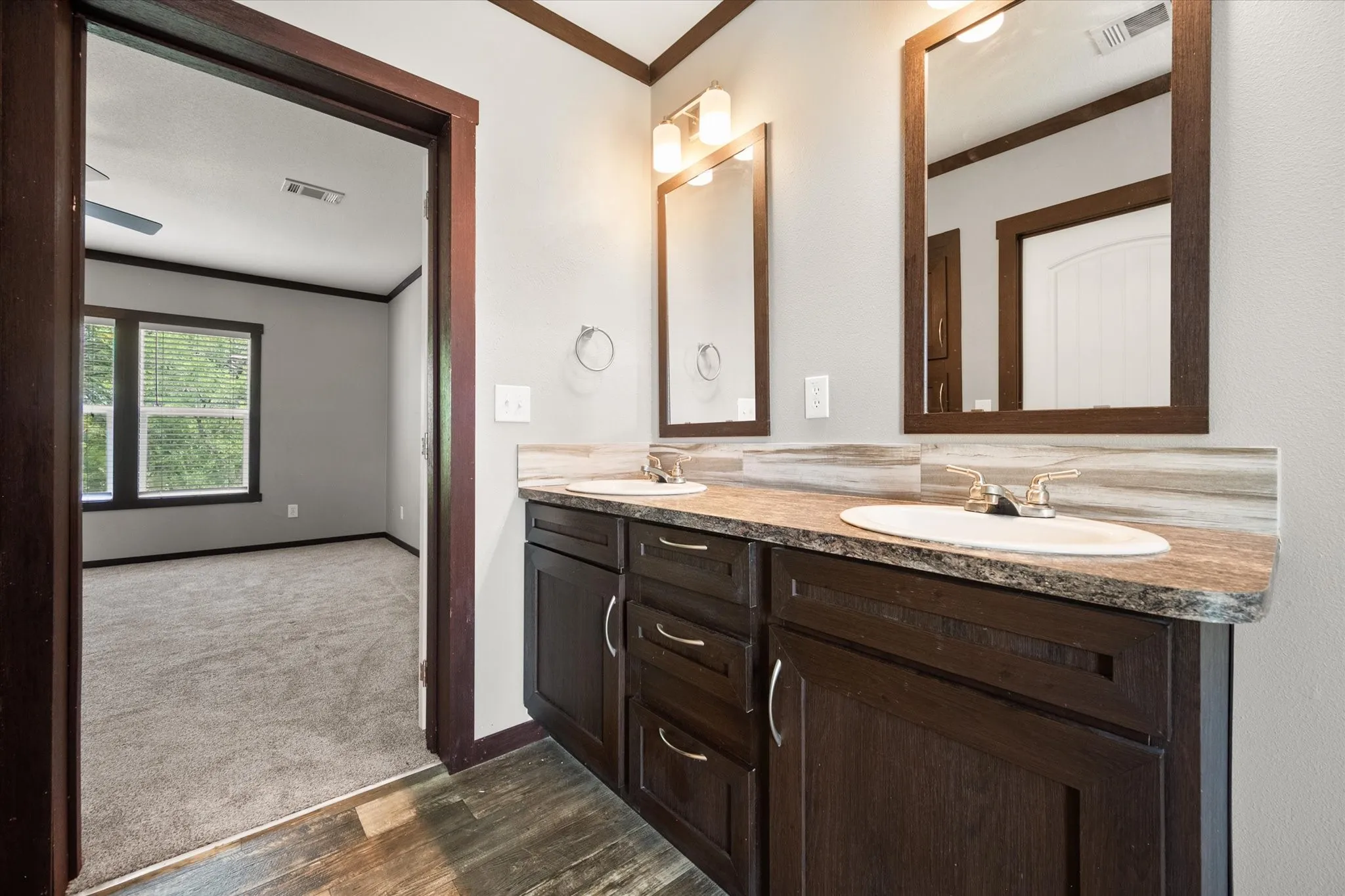 Primary bathroom features dual vanities, abundant storage, and a functional layout designed for daily comfort.