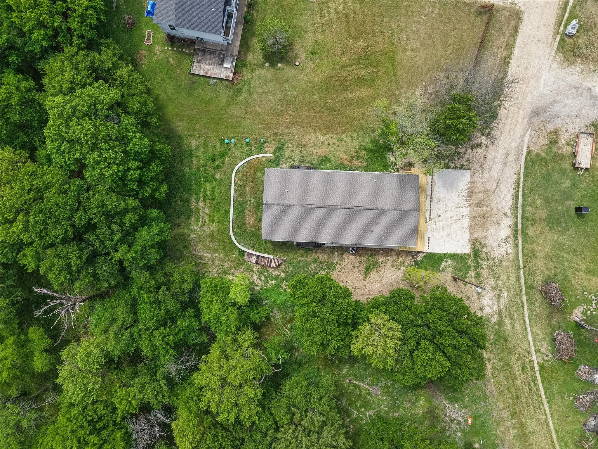 Overhead aerial showcases the homesite layout, mature trees, and outdoor space surrounding this well-maintained property.