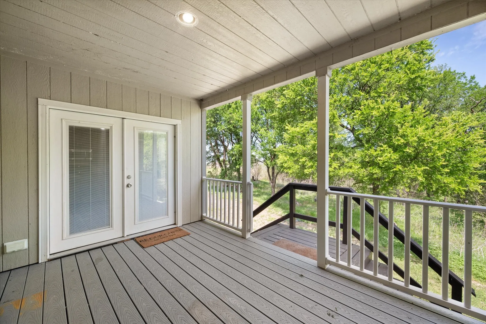 Spacious covered porch provides shaded outdoor living space ideal for entertaining or unwinding after a day at the lake.