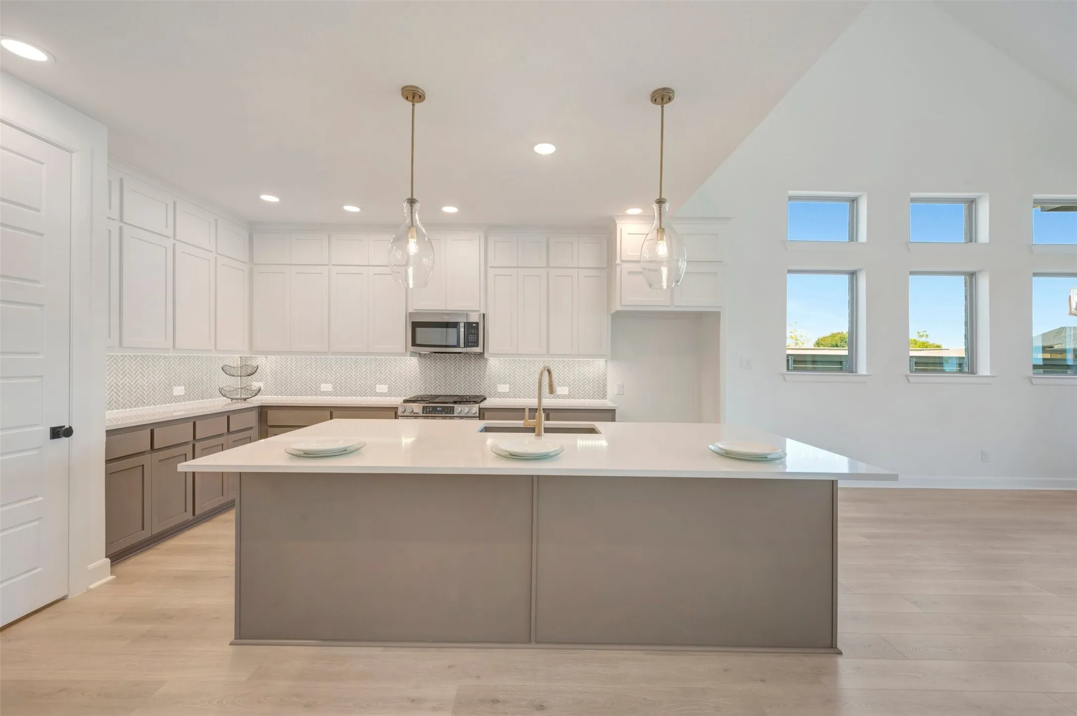 Kitchen featuring a central island with a quartz countertop, stainless steel appliances, and a mosaic tile backsplash