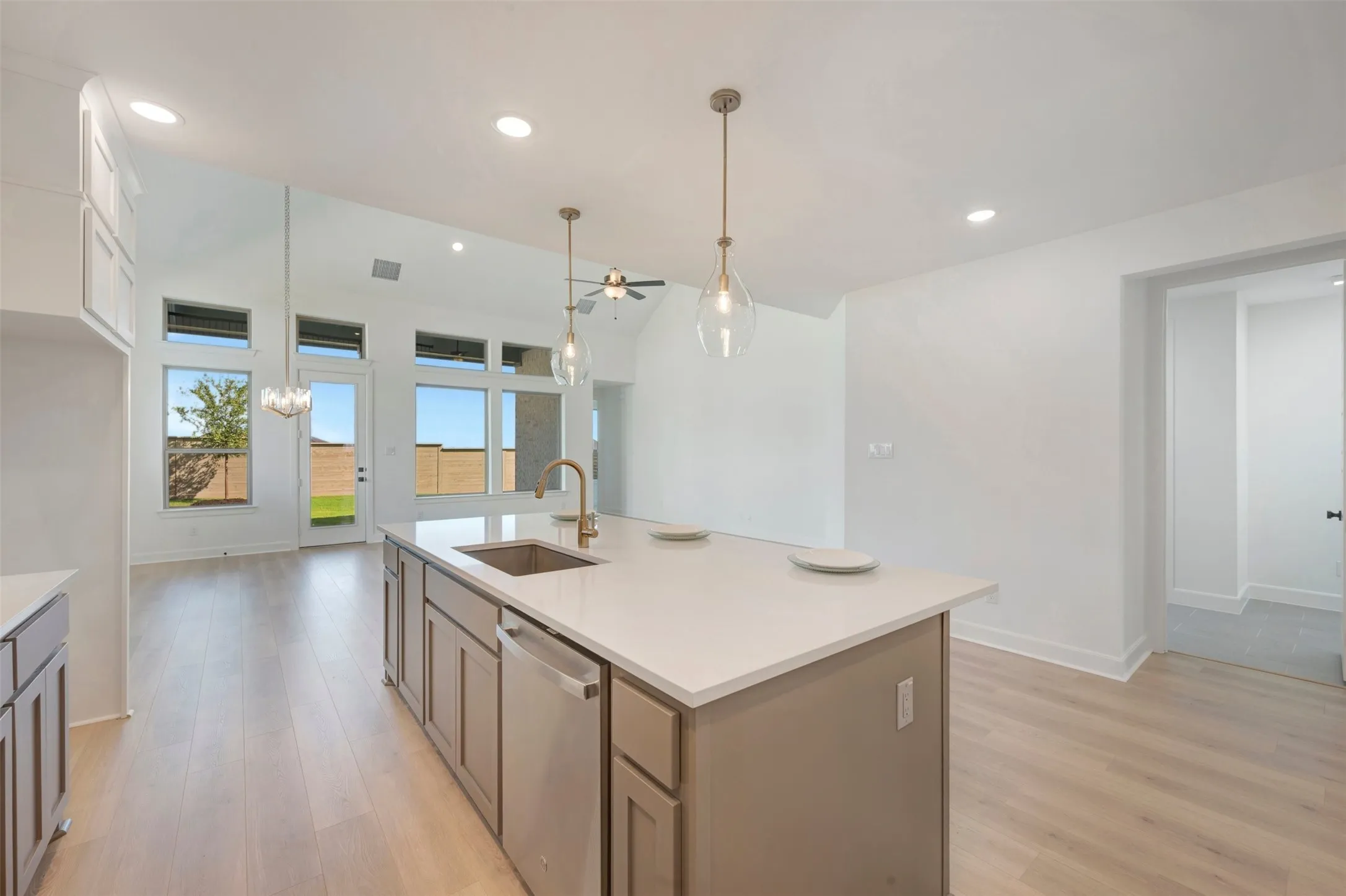 Kitchen island featuring a single-basin sink, bronze hardware, and pendant lighting