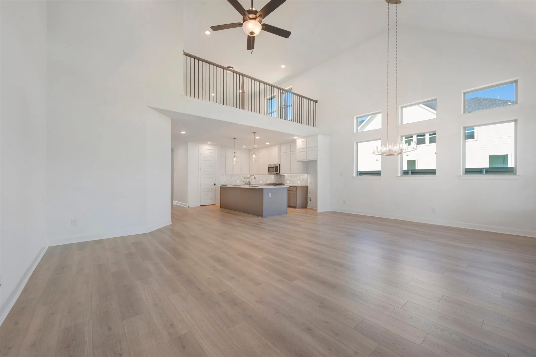 Open-concept living area featuring vaulted ceilings, wood-finish flooring, and a kitchen with an island