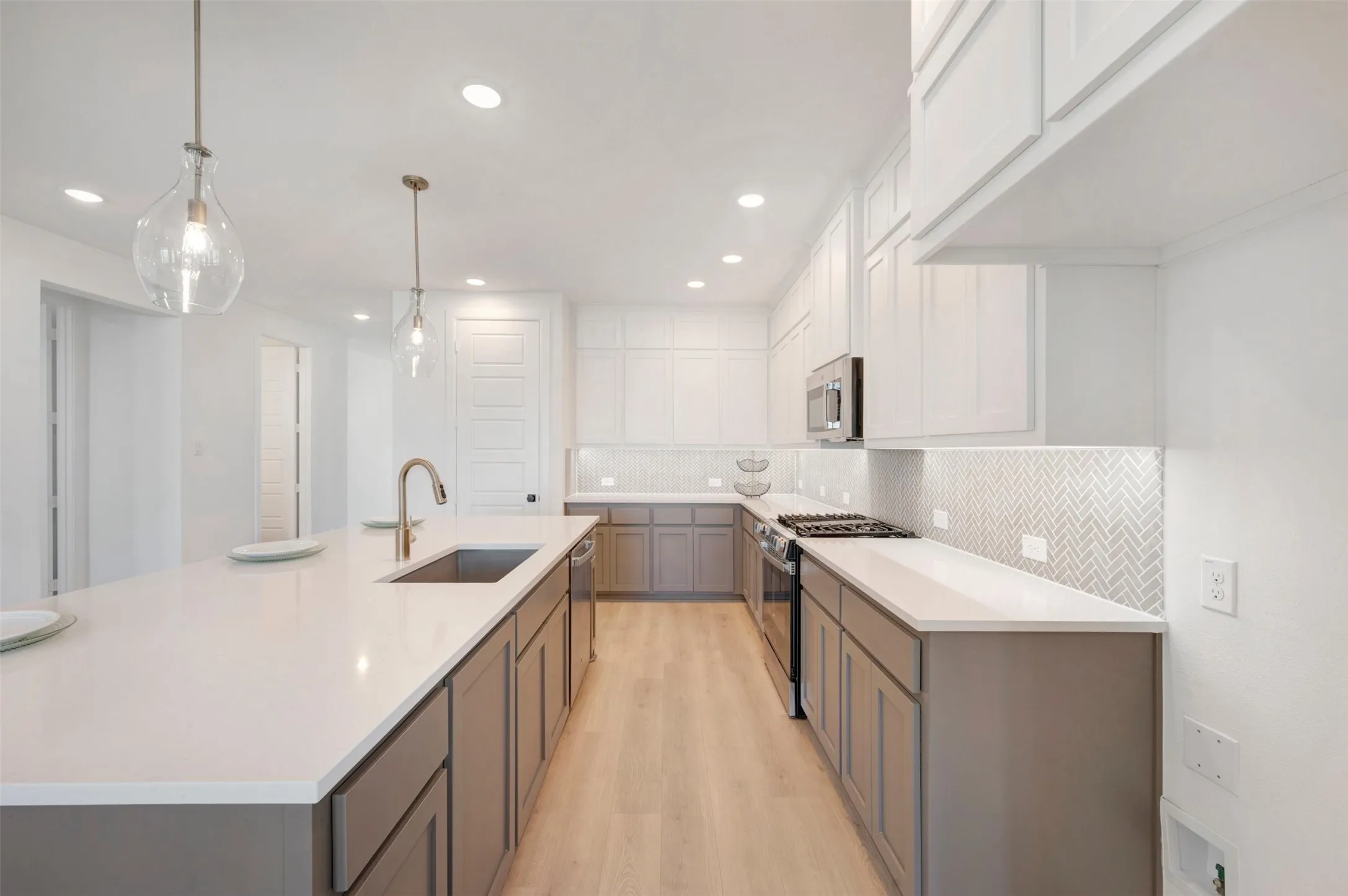 Kitchen featuring a large central island with an undermount sink and gooseneck faucet