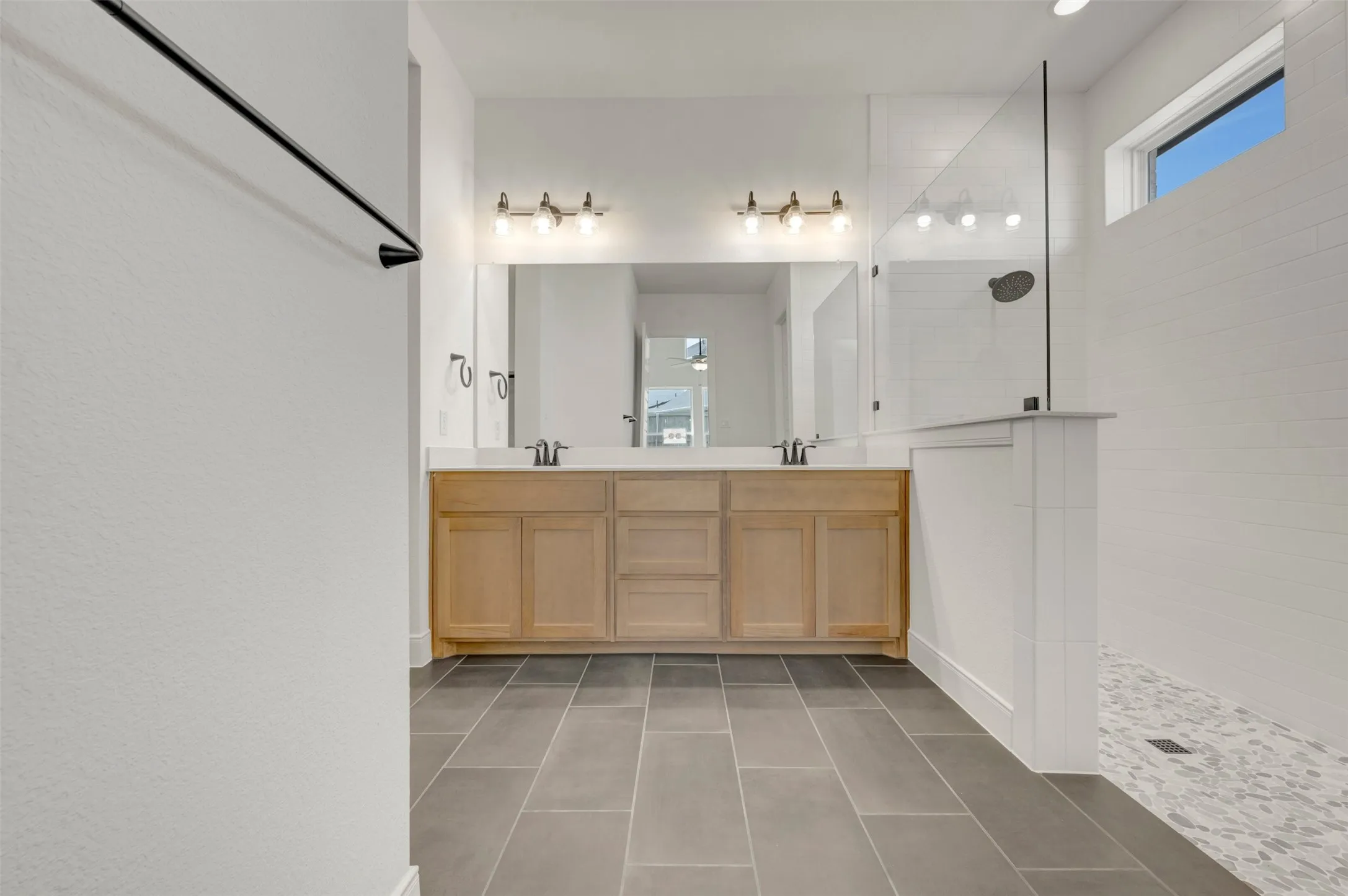Dual vanity with light wood-finish cabinetry and white countertops