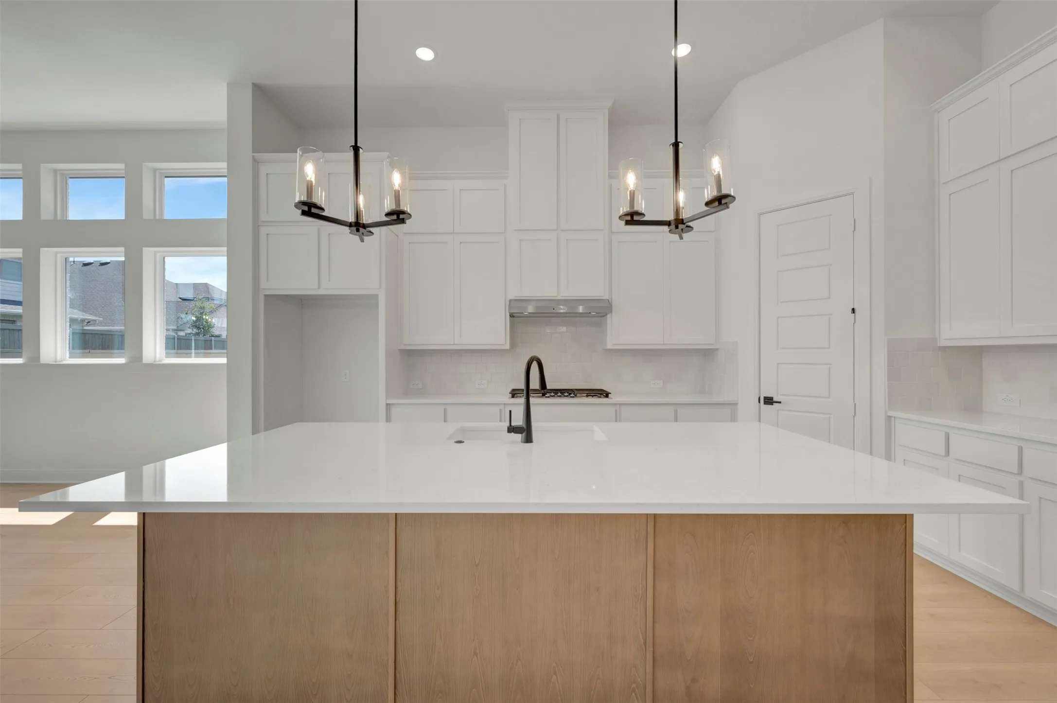 Kitchen featuring a large central island with a light wood-finish base and white countertop