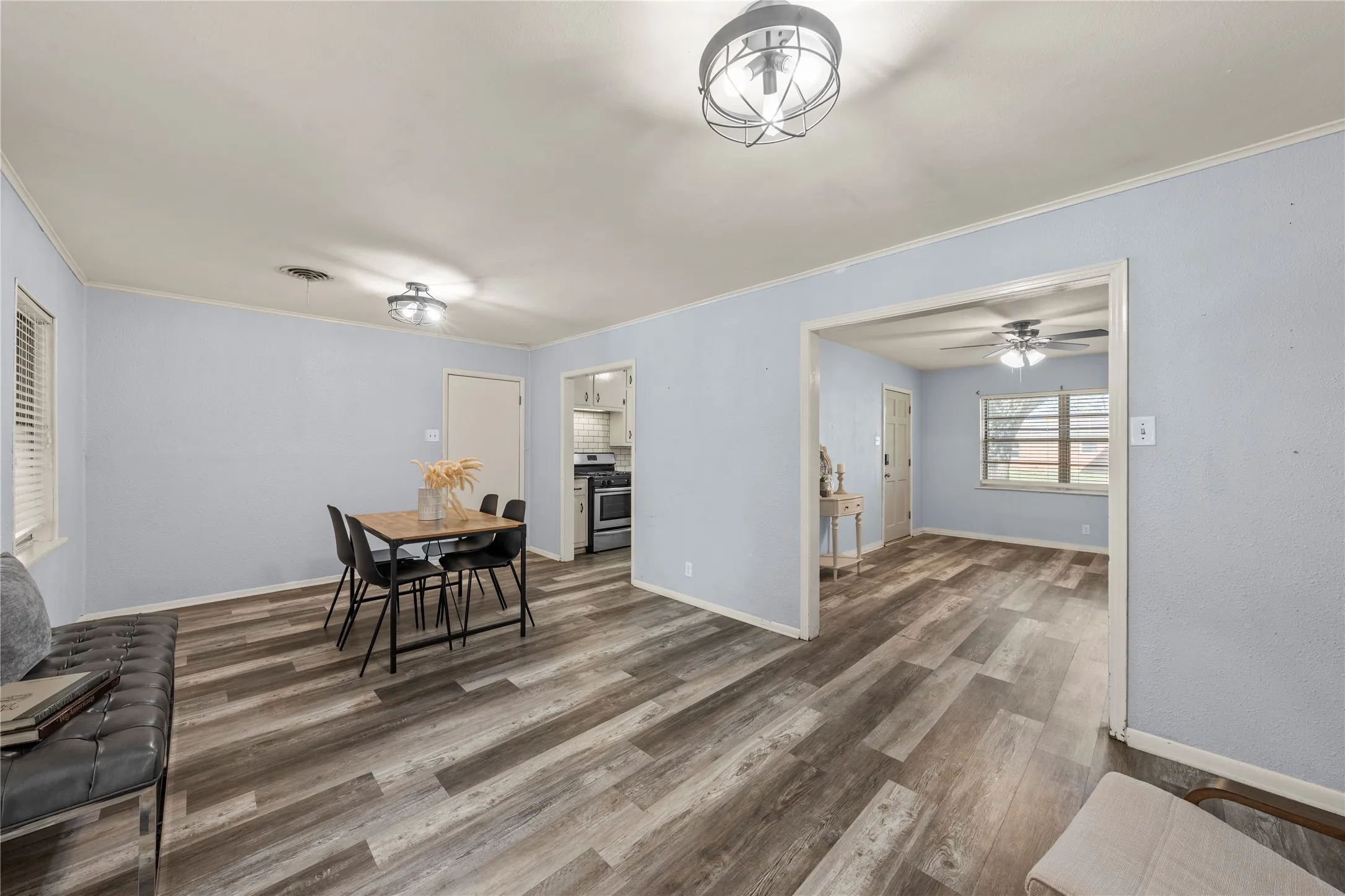 Dining space with wood finished floors, ornamental molding, and ceiling fan