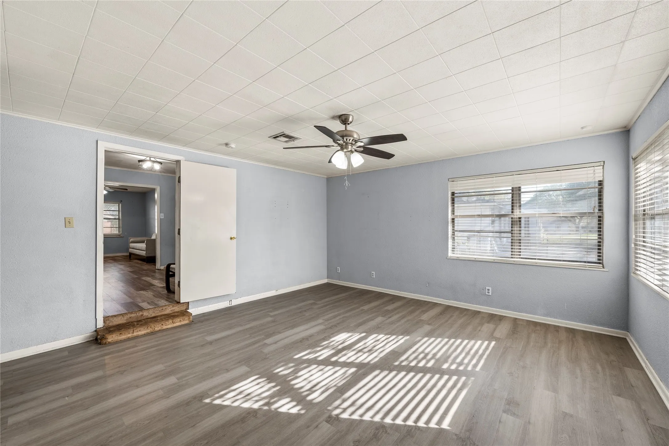 Spare room featuring plenty of natural light, wood finished floors, and ceiling fan