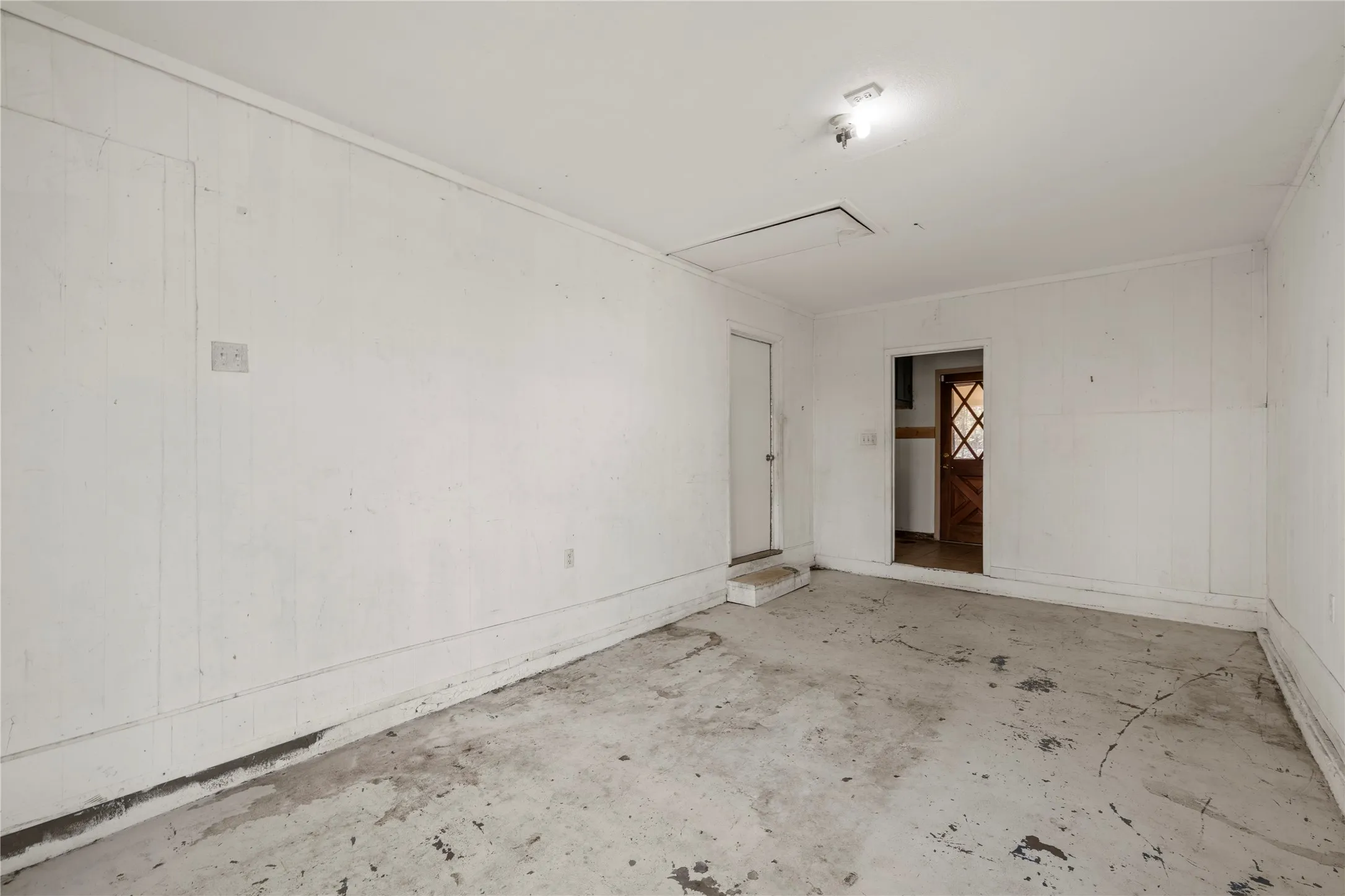 Spare room with unfinished concrete flooring and wooden walls