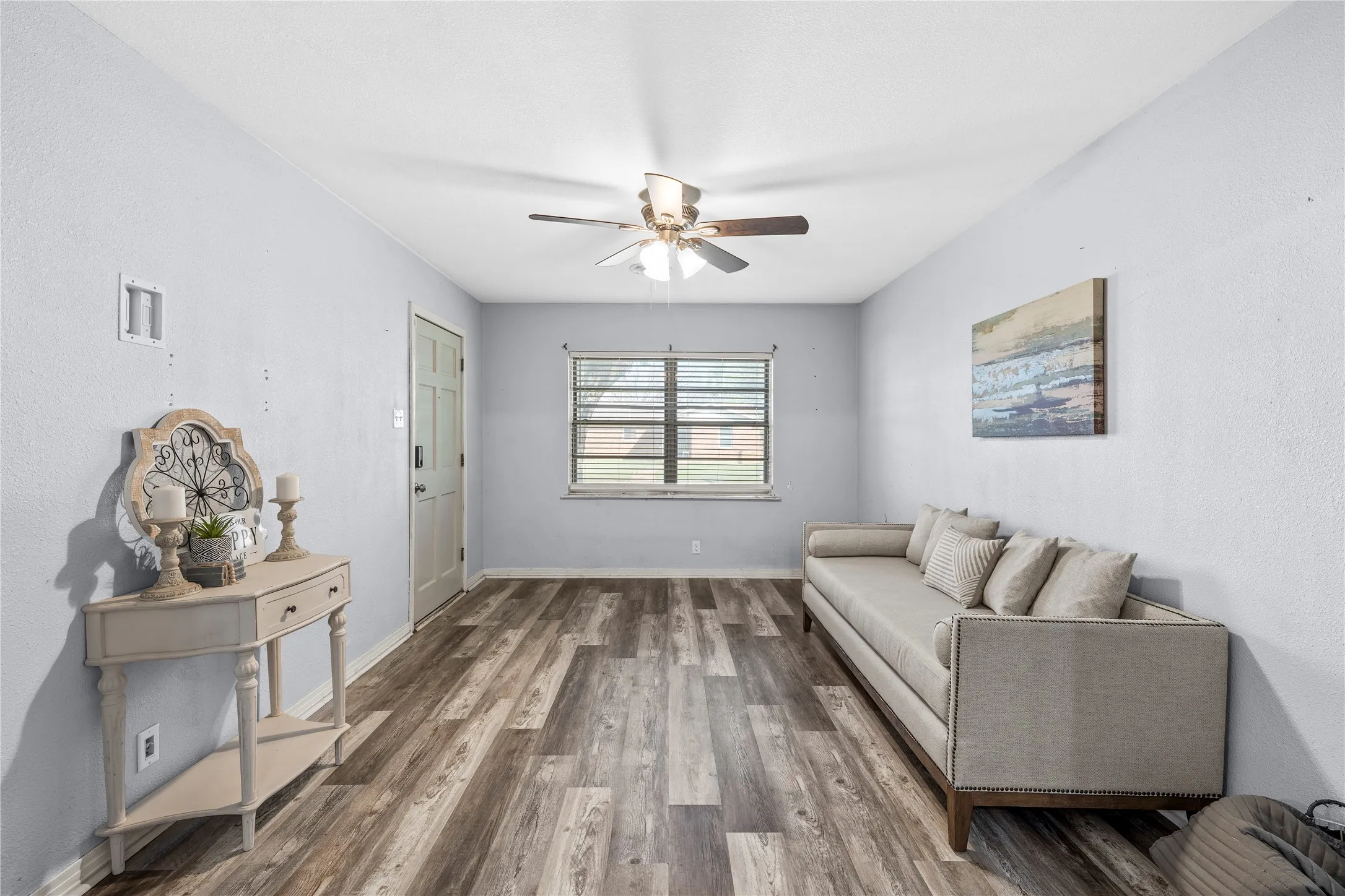 Living area featuring wood finished floors and a ceiling fan