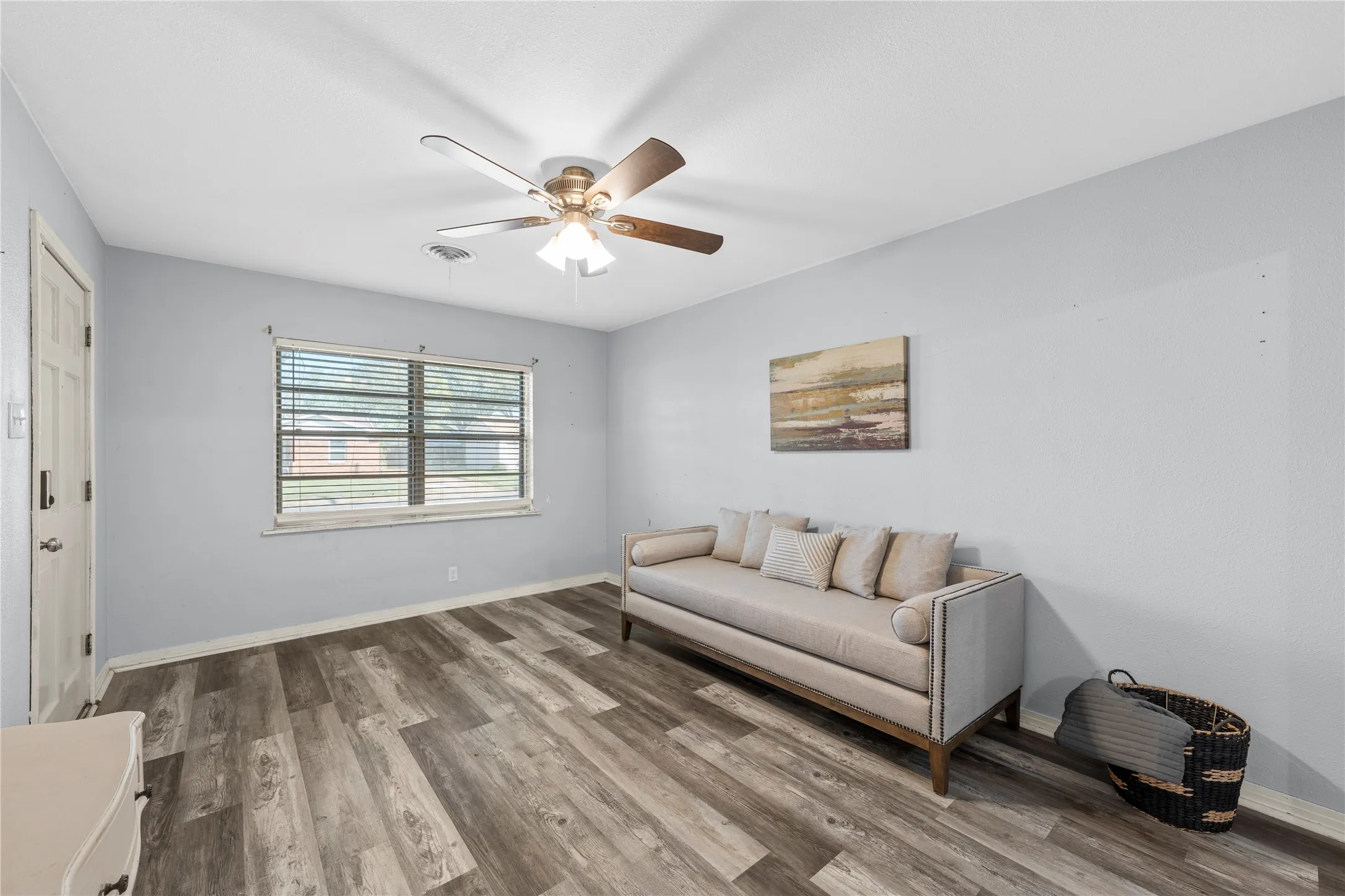 Sitting room with wood finished floors and a ceiling fan