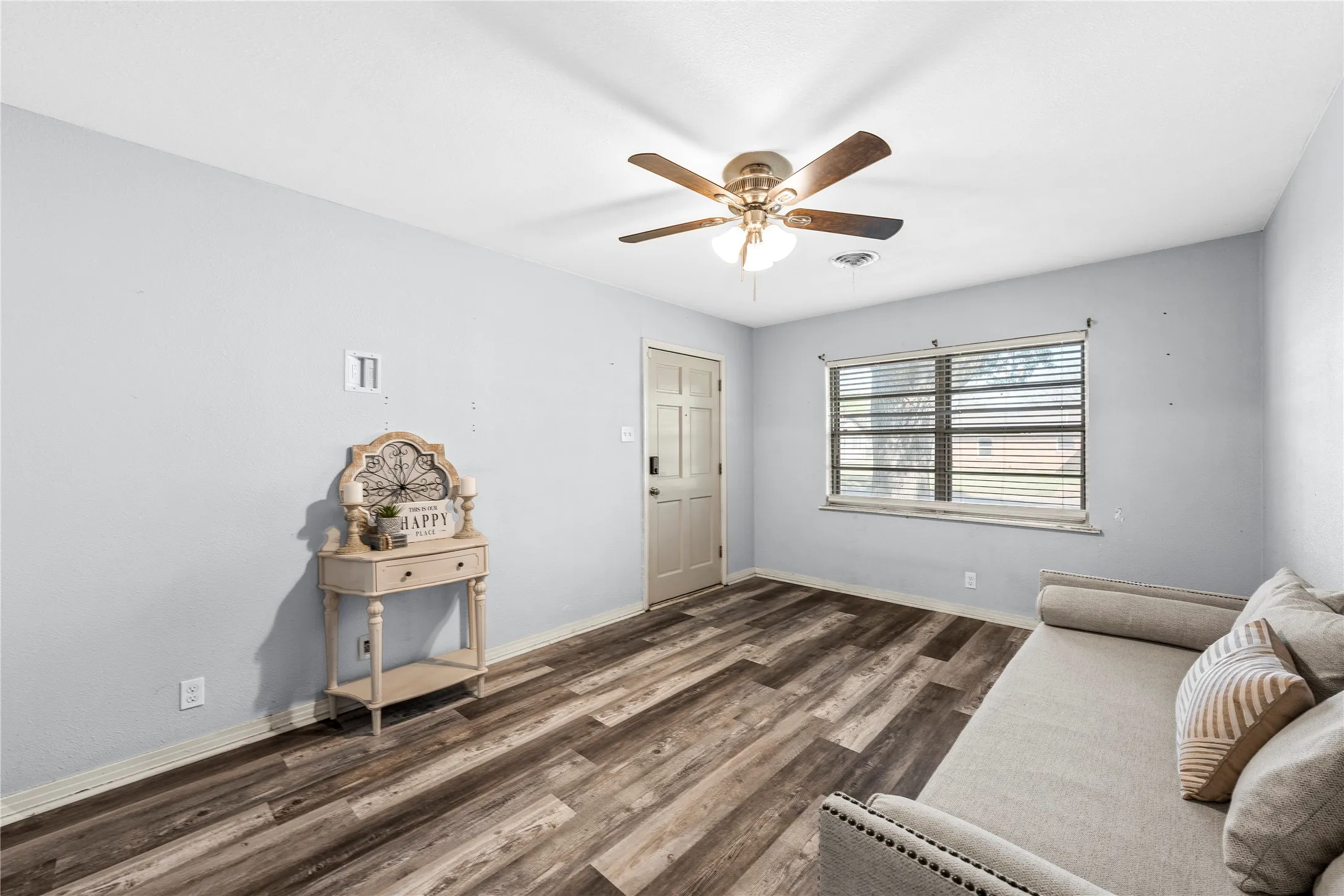 Living area with dark wood finished floors and a ceiling fan