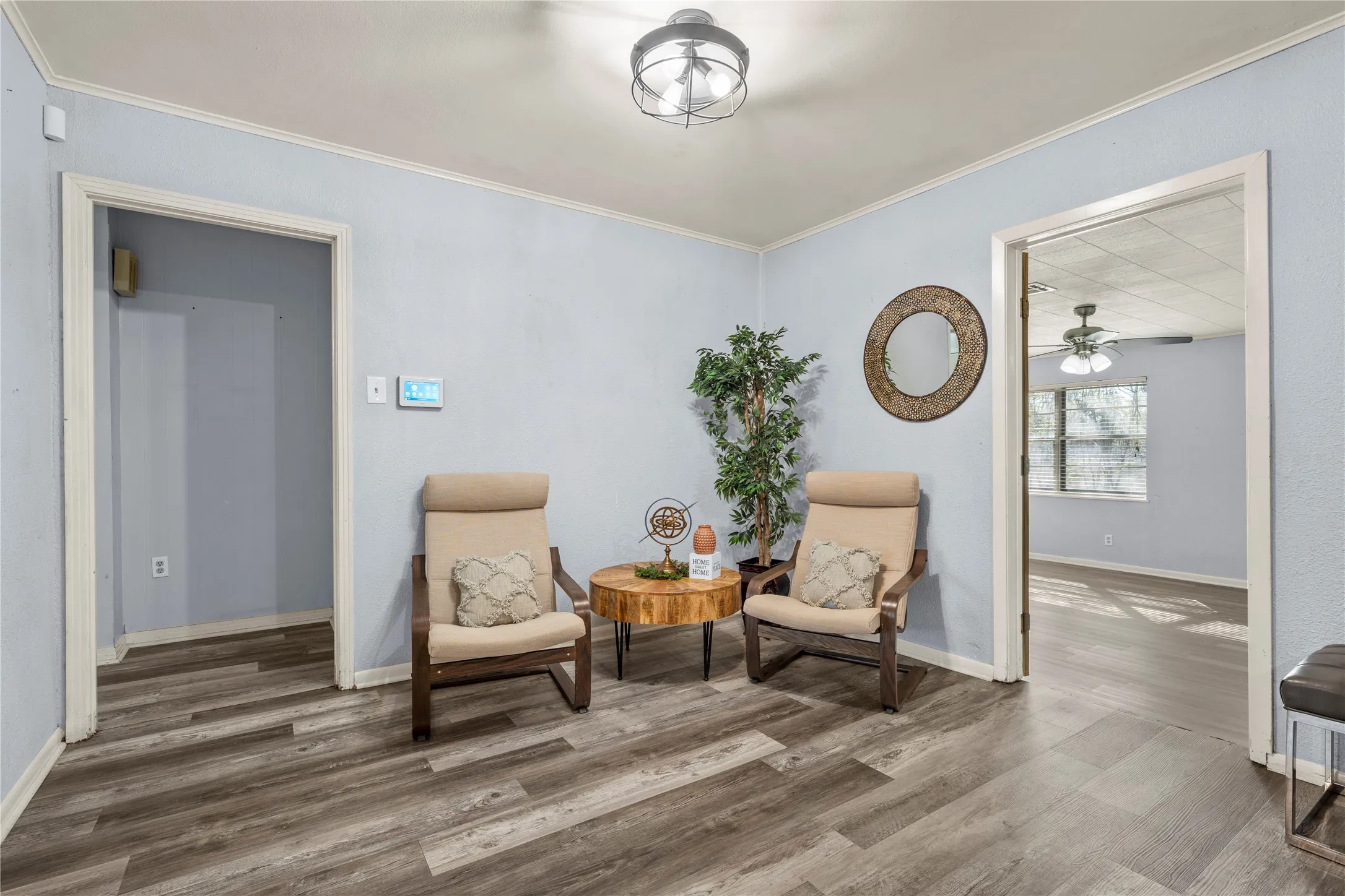 Living area with wood finished floors, a ceiling fan, and ornamental molding