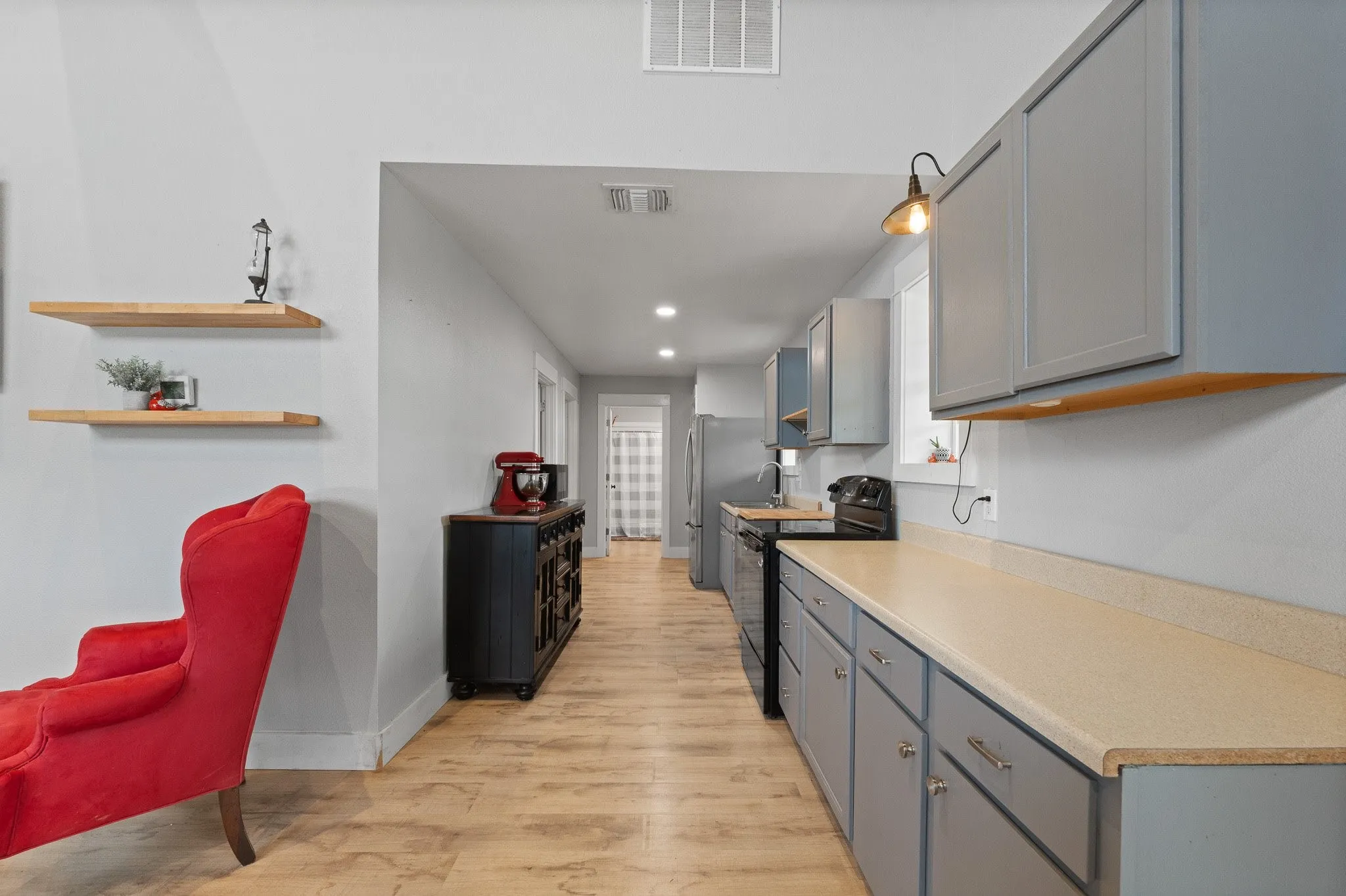 Kitchen with electric range, light wood finished floors, light countertops, recessed lighting, and gray cabinetry