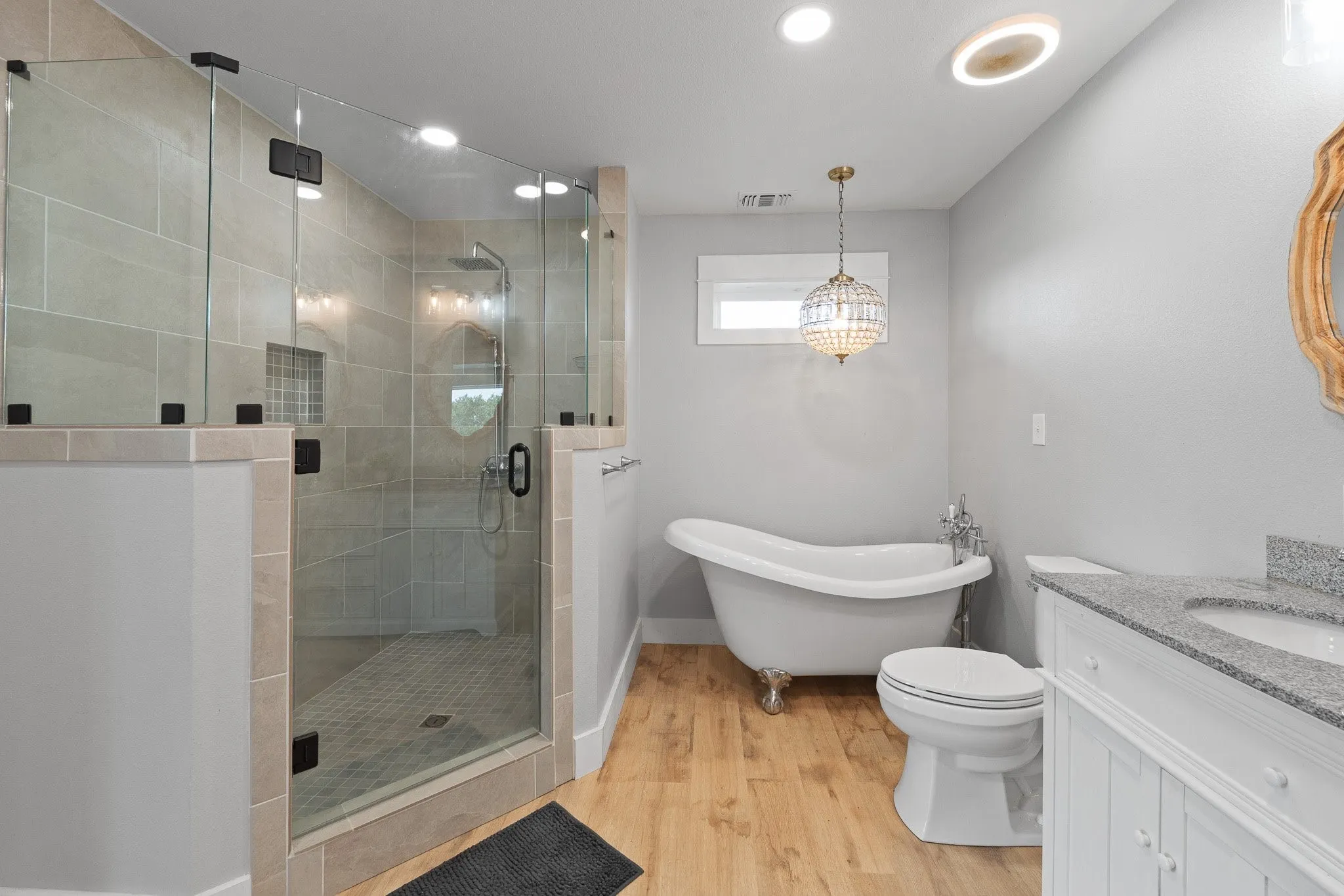 Primary Bathroom featuring vanity, a stall shower, a freestanding tub, light wood finished floors, and recessed lighting
