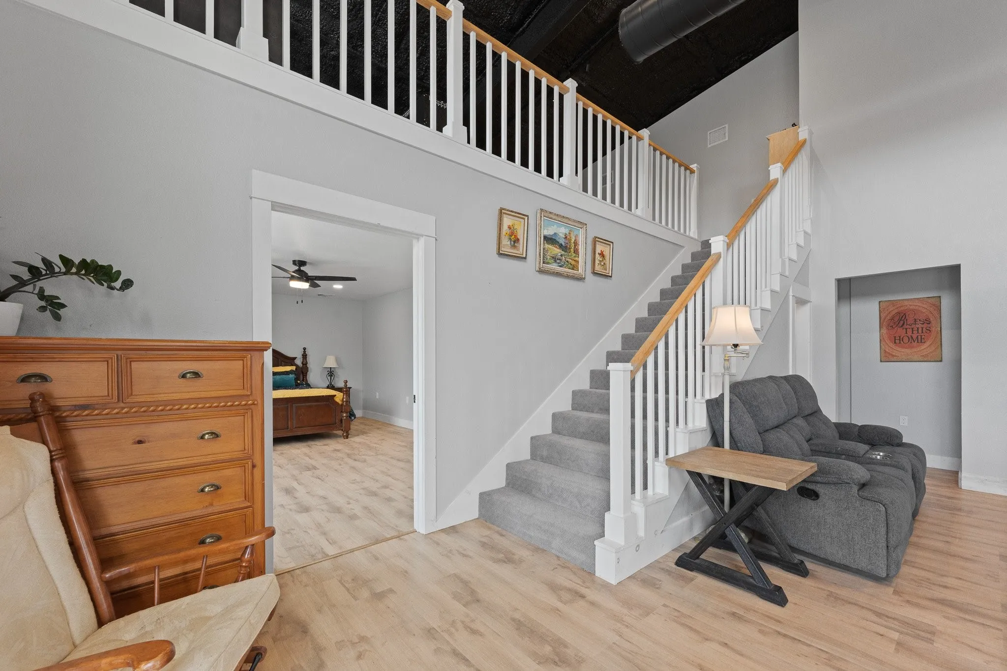 Stairway with wood finished floors and a high ceiling