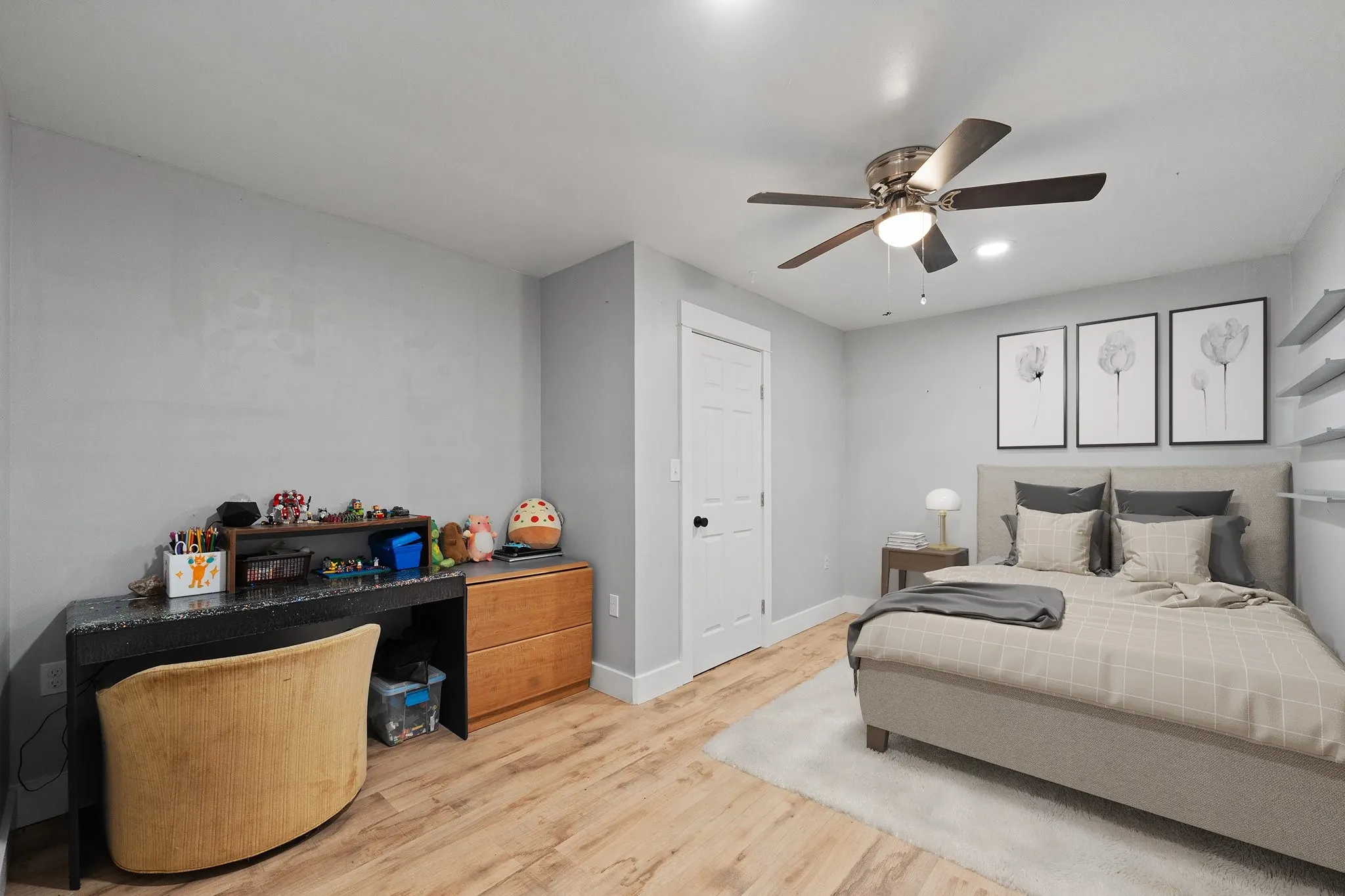 Bedroom 2 with light wood finished floors and ceiling fan (Bed is Staged for visual purposes
