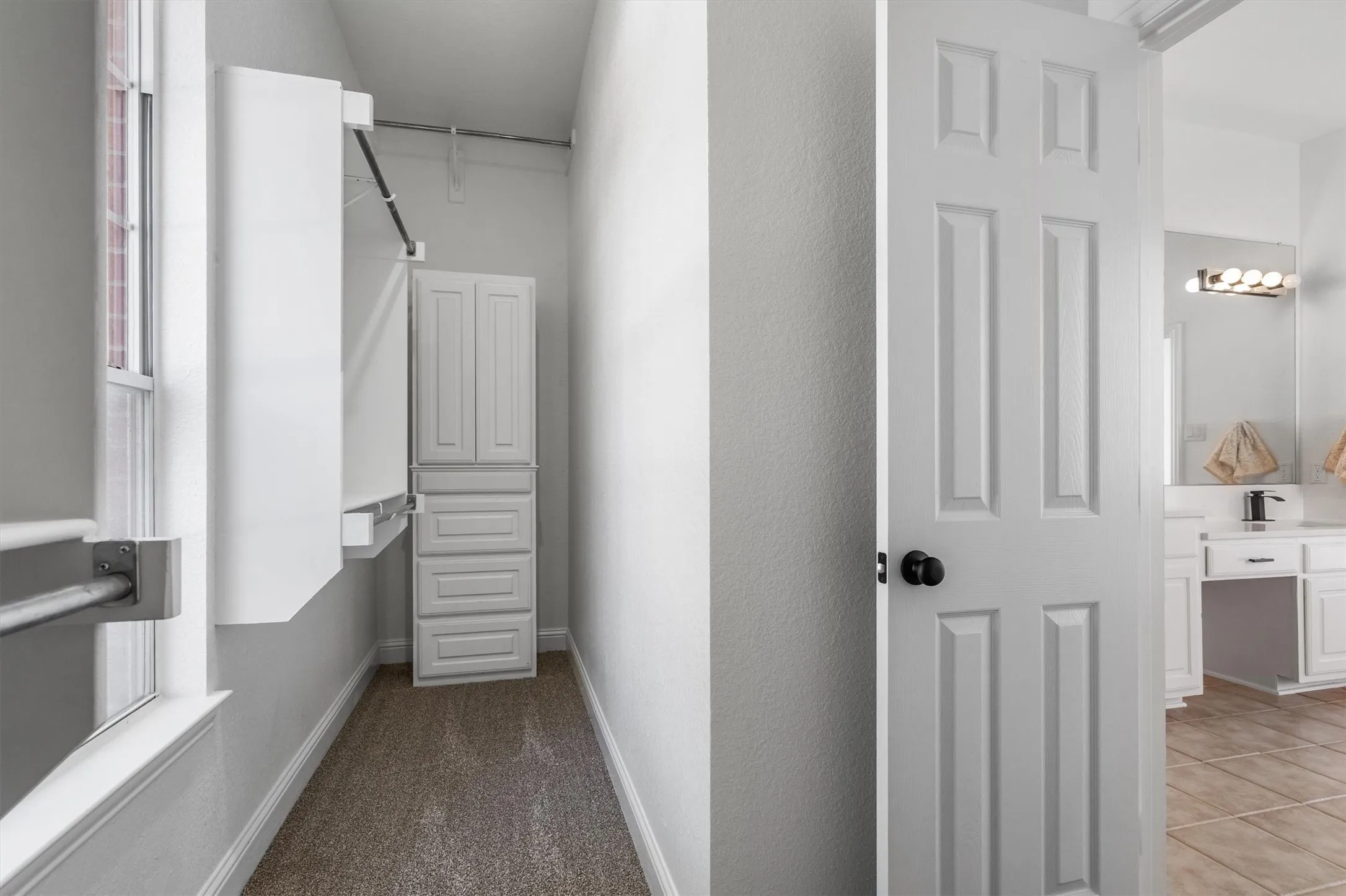 Walk in closet located in primary bathroom with tons of storage!