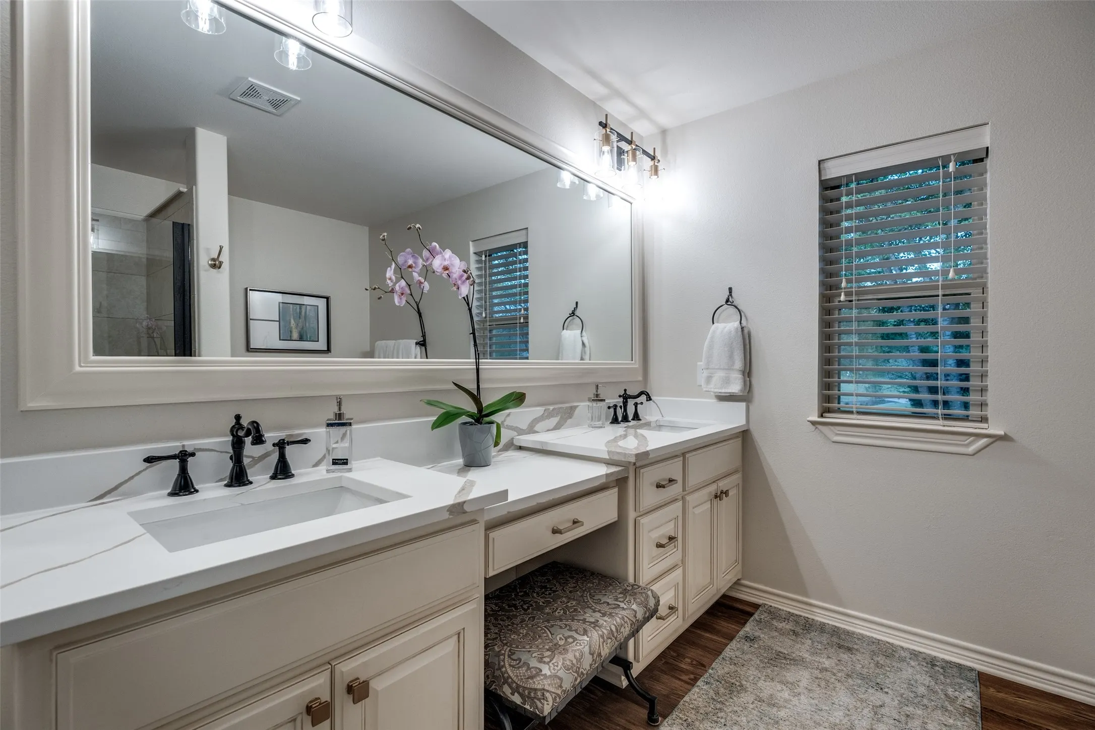 Full bathroom featuring double vanity and dark wood finished floors