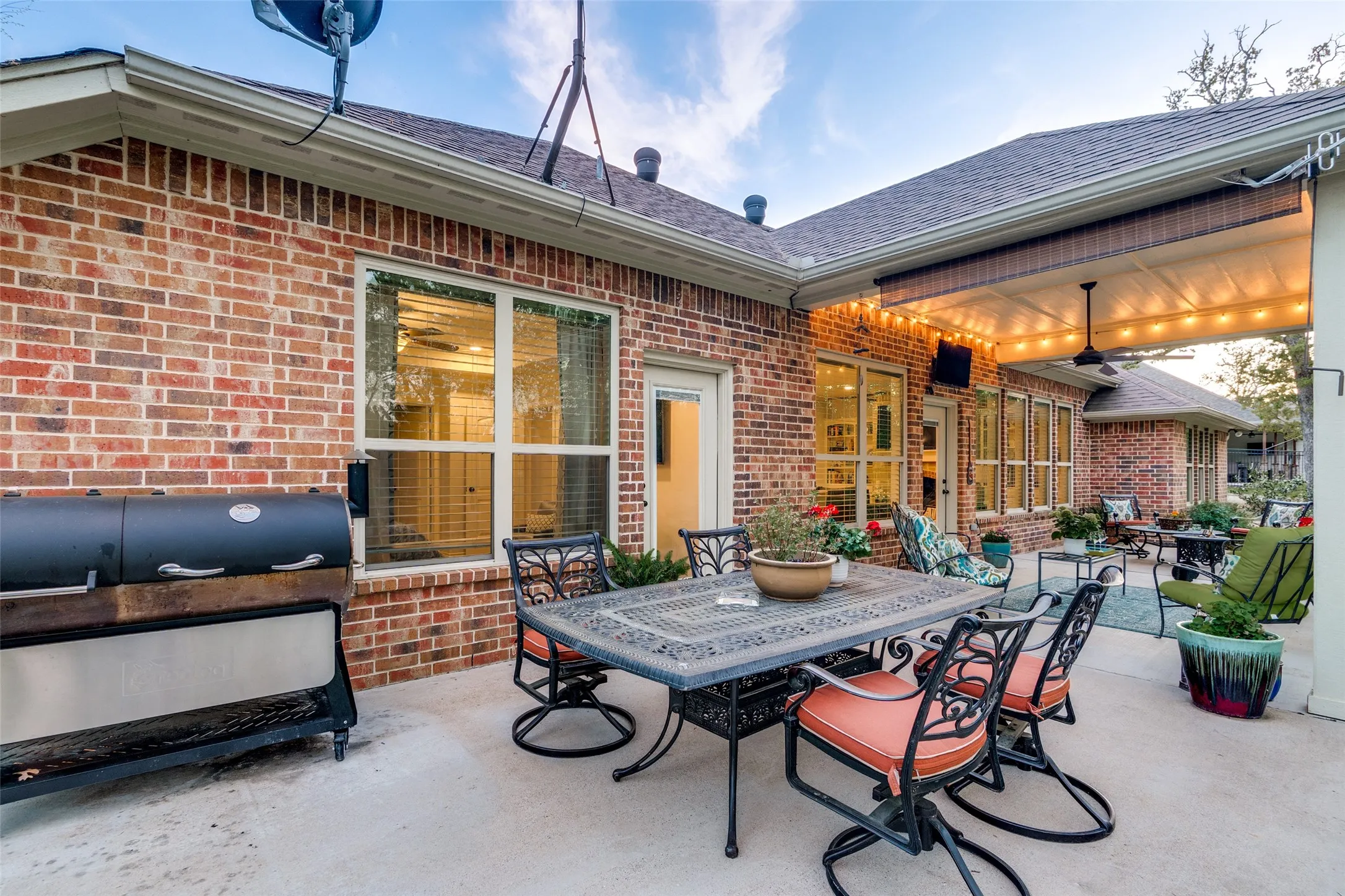 View of patio with outdoor dining space, a grill, and ceiling fan