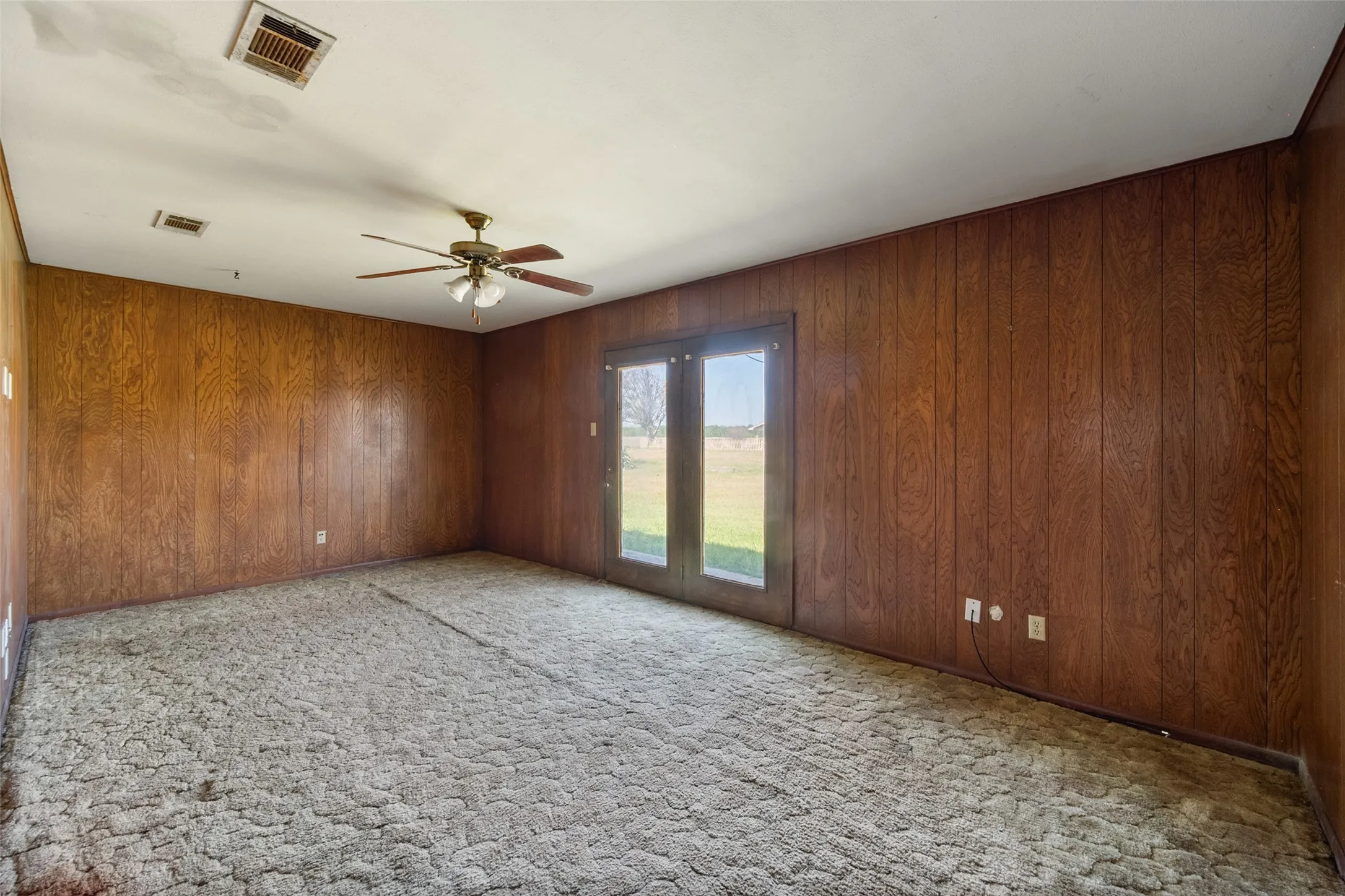 Unfurnished living room with light colored carpet and paneling