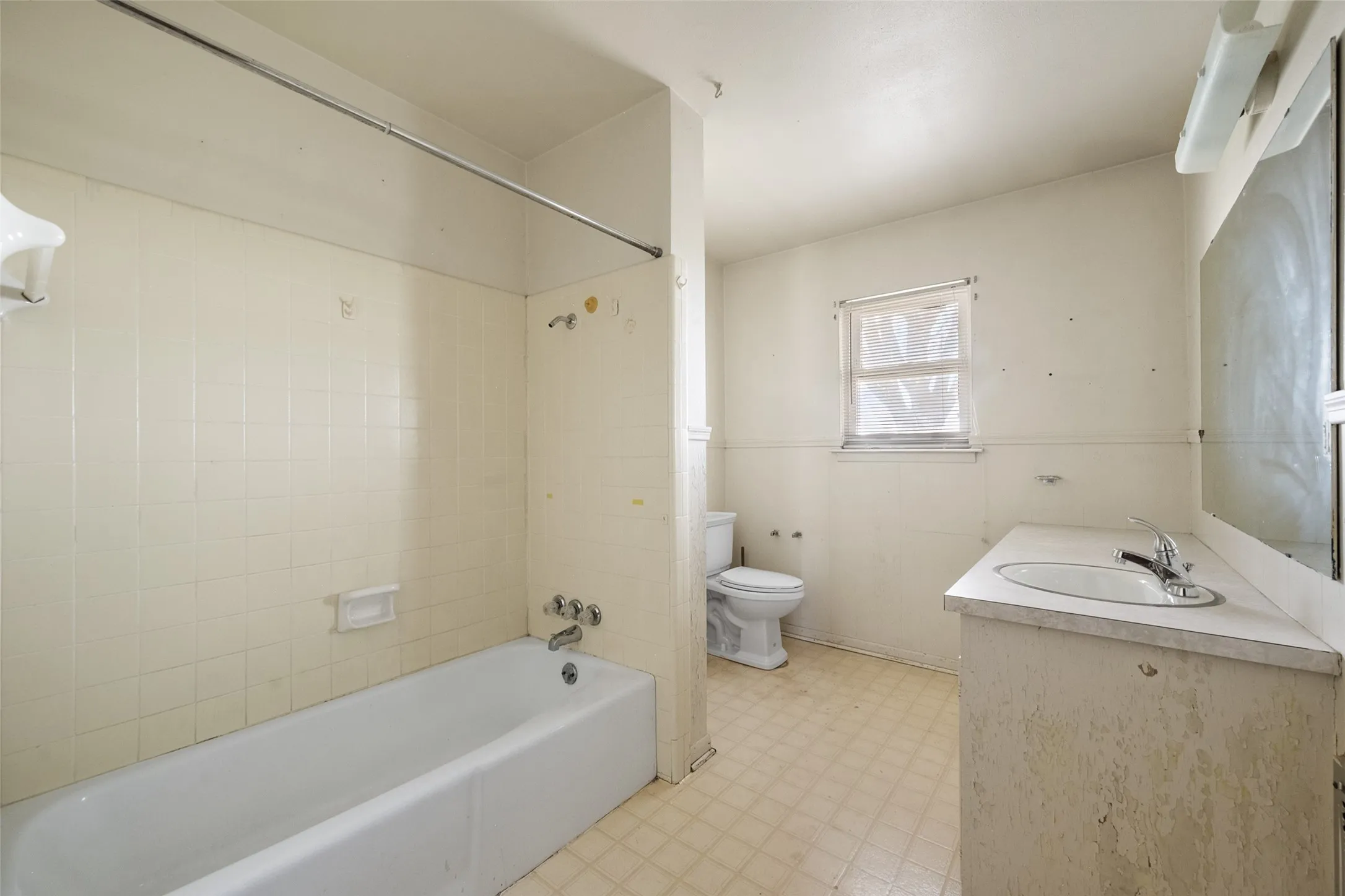 Bathroom featuring light flooring, vanity, and shower / bathtub combination