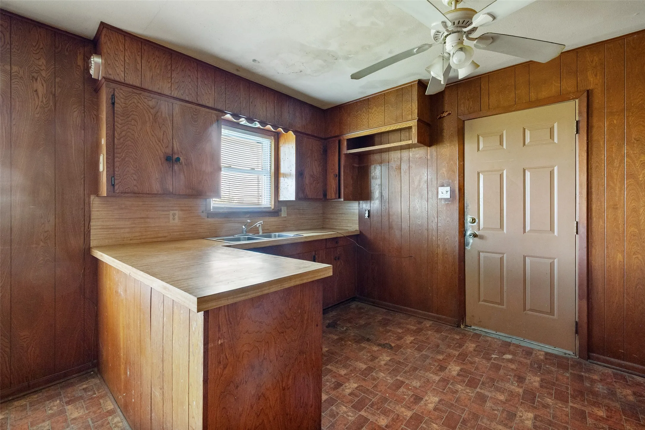 Kitchen with a peninsula, brick patterned flooring and light countertops
